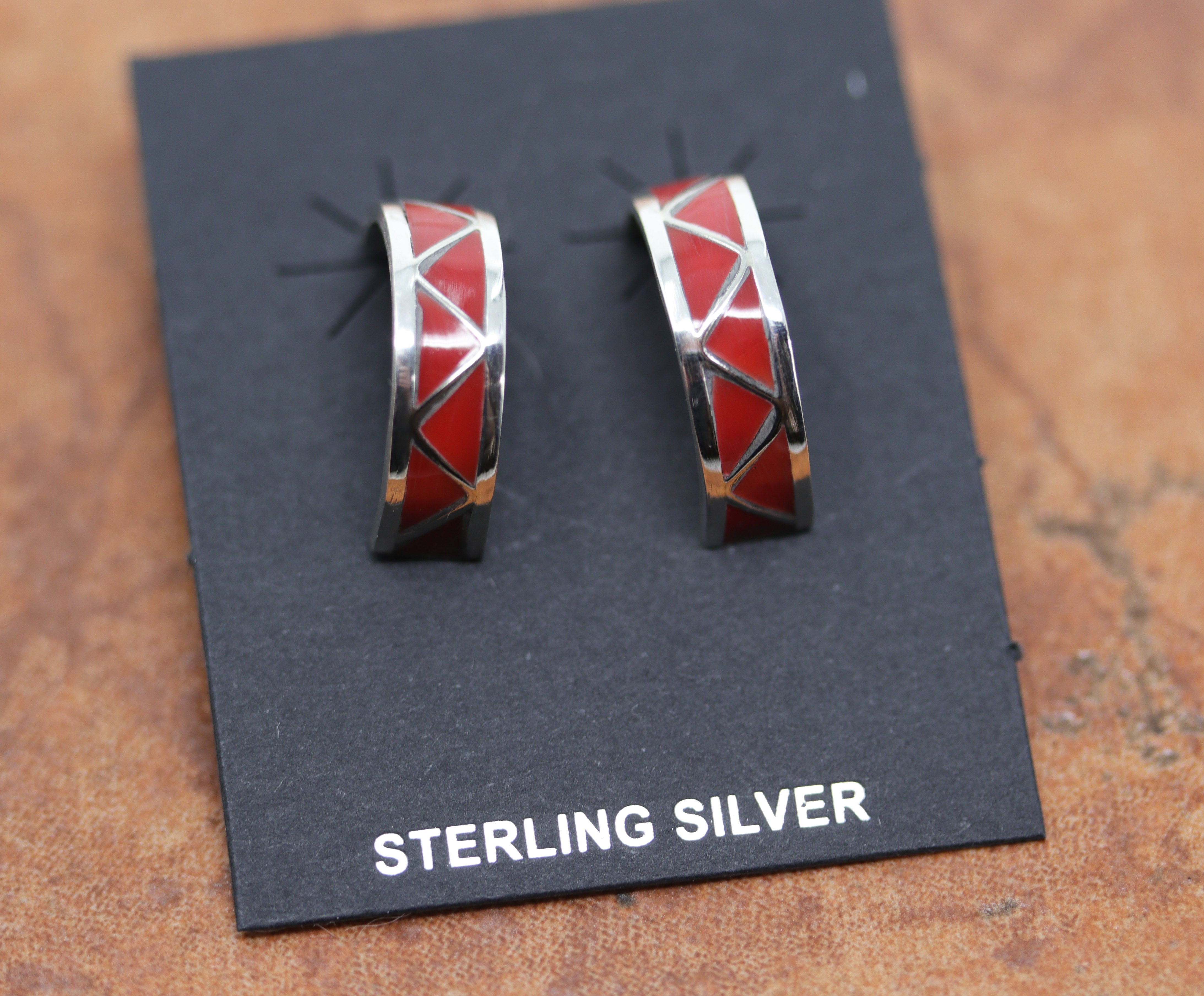 Beautiful Zuni Native American earrings. They are made from sterling silver and coral. Each earring is 1" in length, and about 1/4" in width.