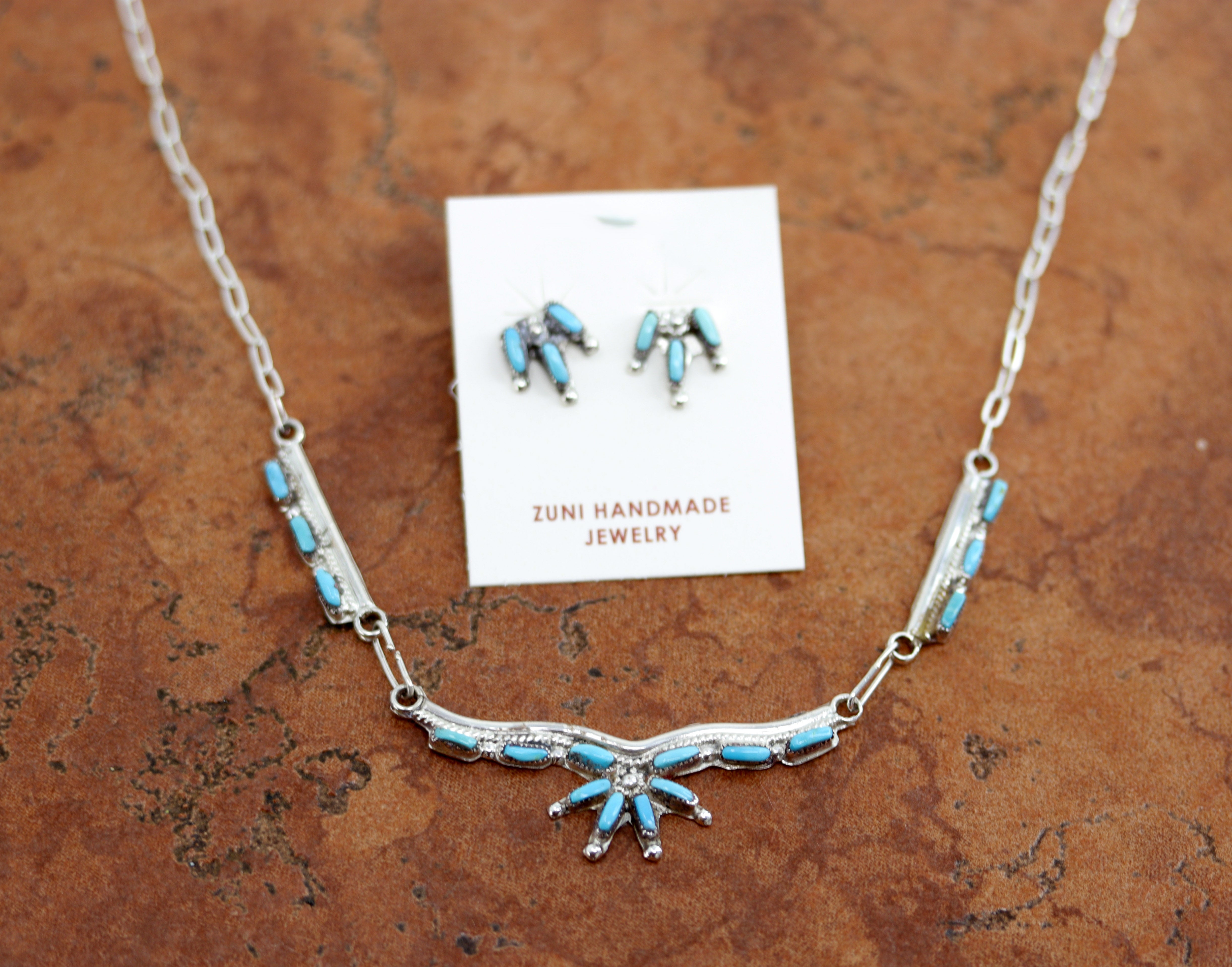 Zuni Native American Necklace and Earrings Set. It is made from sterling silver and turquoise. The total length is about 18". The center pendant measures 5 1/2" by 3/4". The earrings are 5/8" in length.