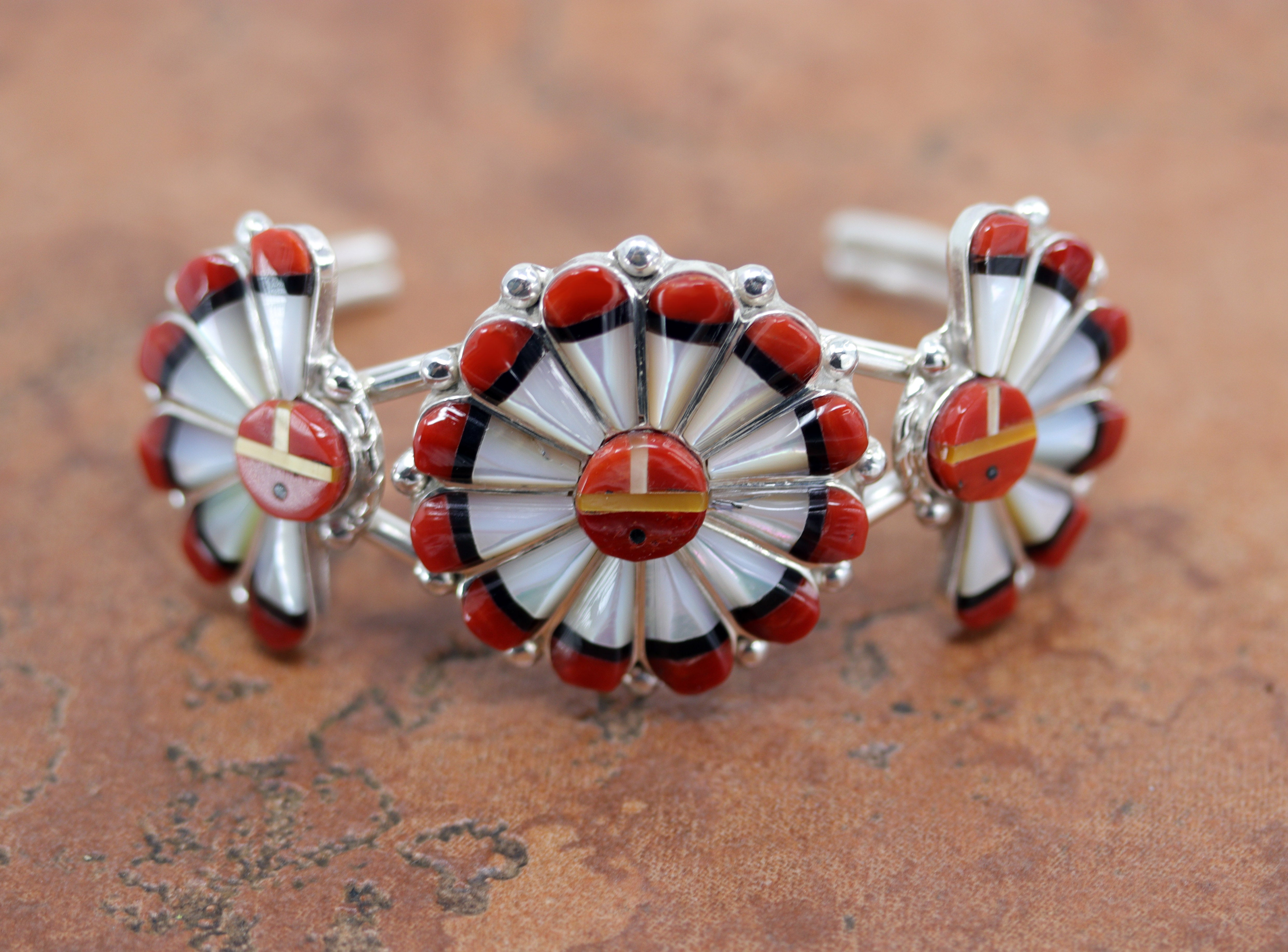 Zuni Native American bracelet. It is made from sterling silver and multi-stone inlay. It is about 5 1/4" around not including the opening and the widest point is about 1 1/2". The opening is about 1 1/4", and it is partly flexible.