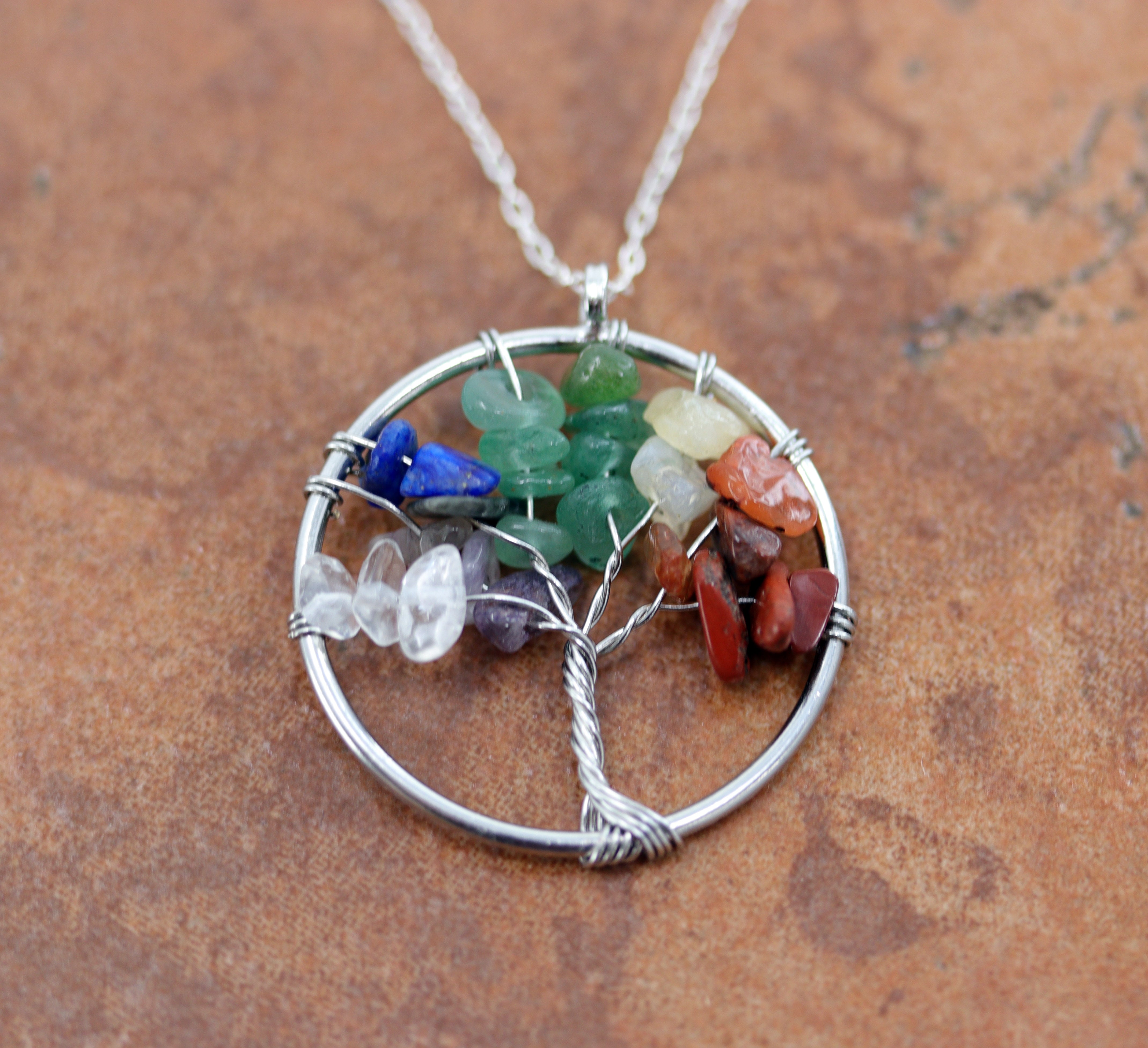 It is made from zinc alloy and gemstone chips. The pendant is about 1 1/4" in length including the bail, and about 1 1/4" wide. The sterling silver chain is 18" long. 