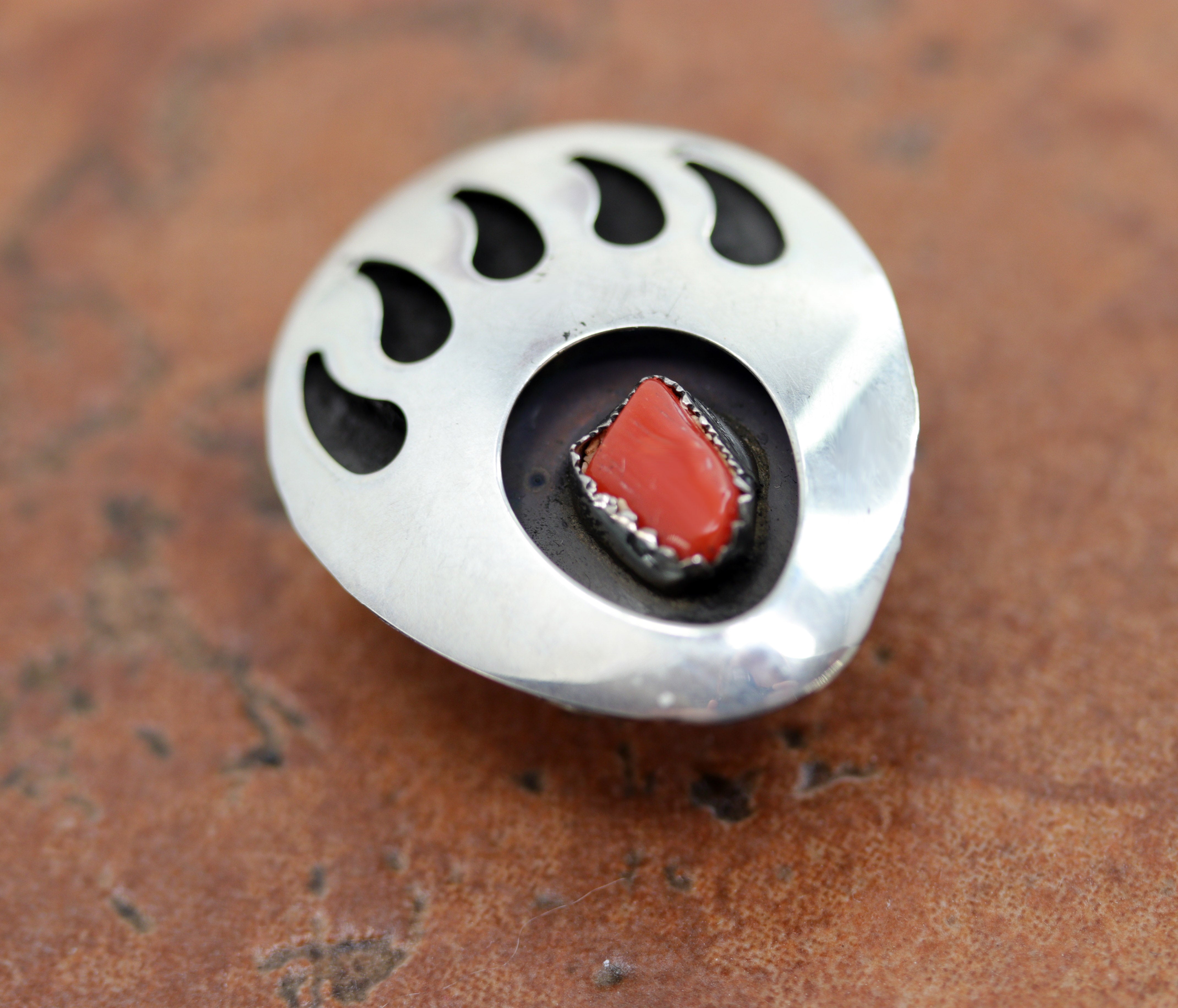 A very nice Navajo Native American bear paw button made from sterling silver and coral. It is 1 3/8" in length and 1 1/8" in width.