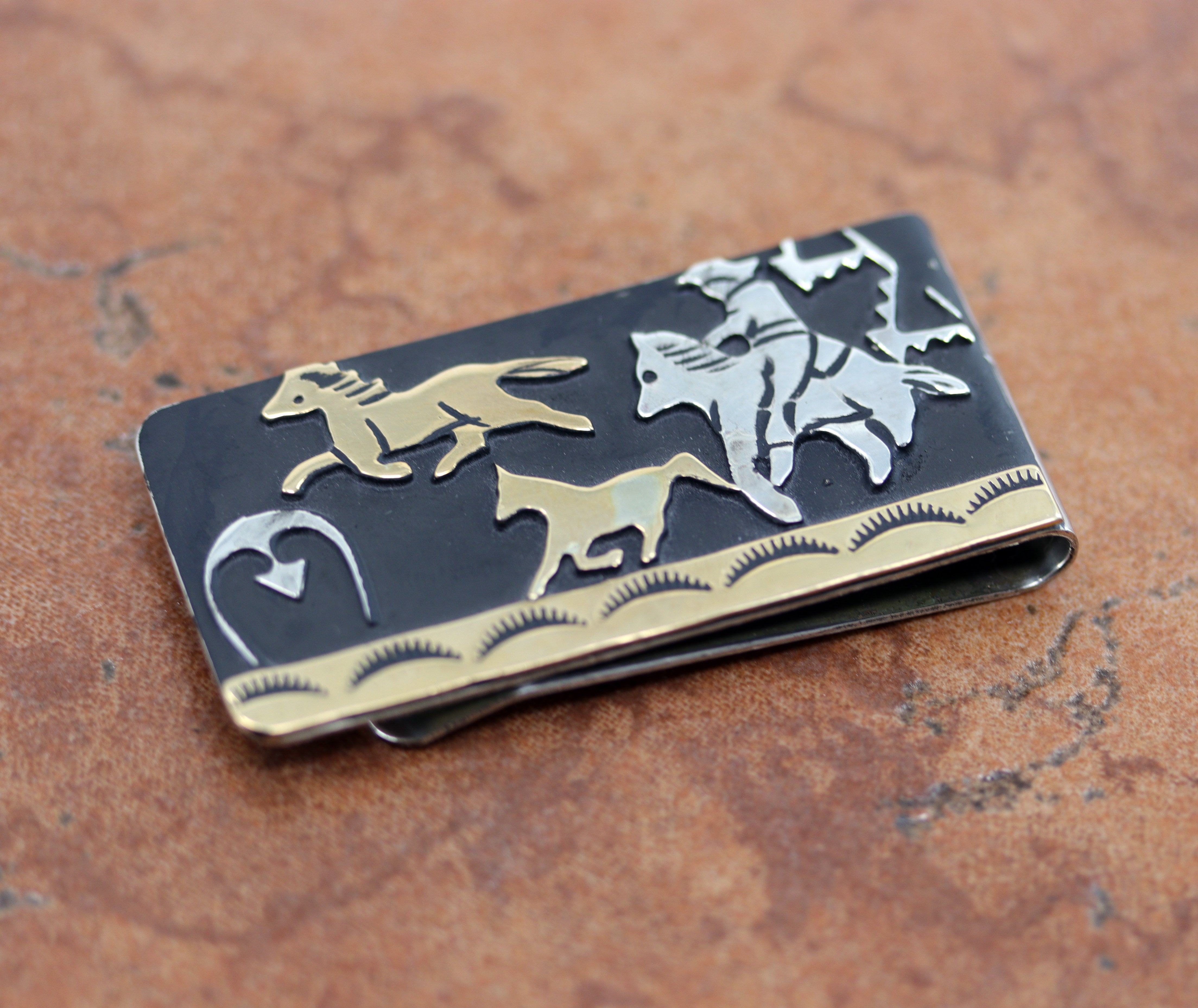 Navajo Native American money clip. It is made from sterling silver, and gold overlay. The lower part of the money clip is made from nickel to give it more durability. It is about 2 1/8" in length and 1" wide.