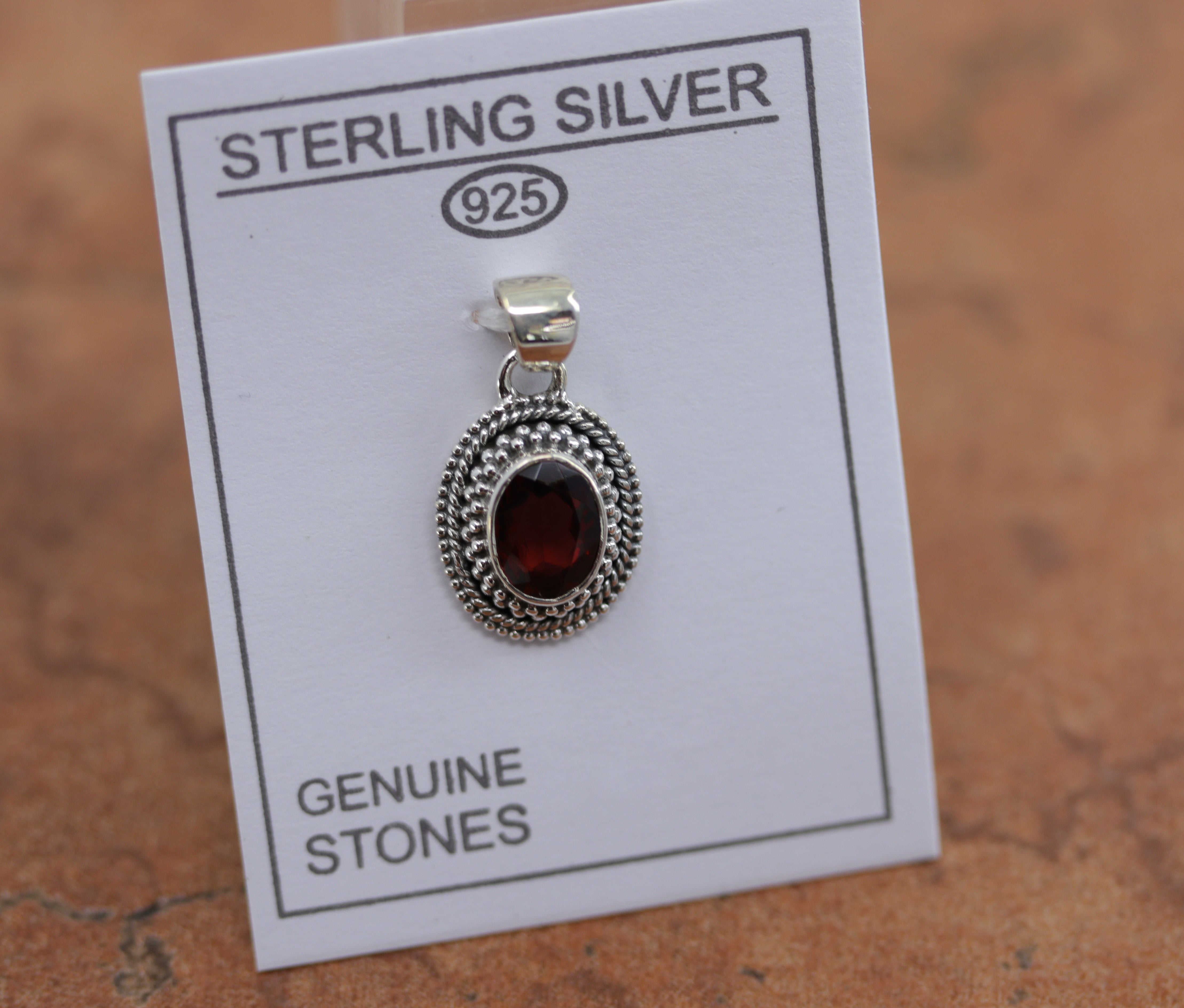 A beautiful oval pendant made from Sterling Silver and garnet. It is about 1" in length including the bail, and about 5/8" in width. 