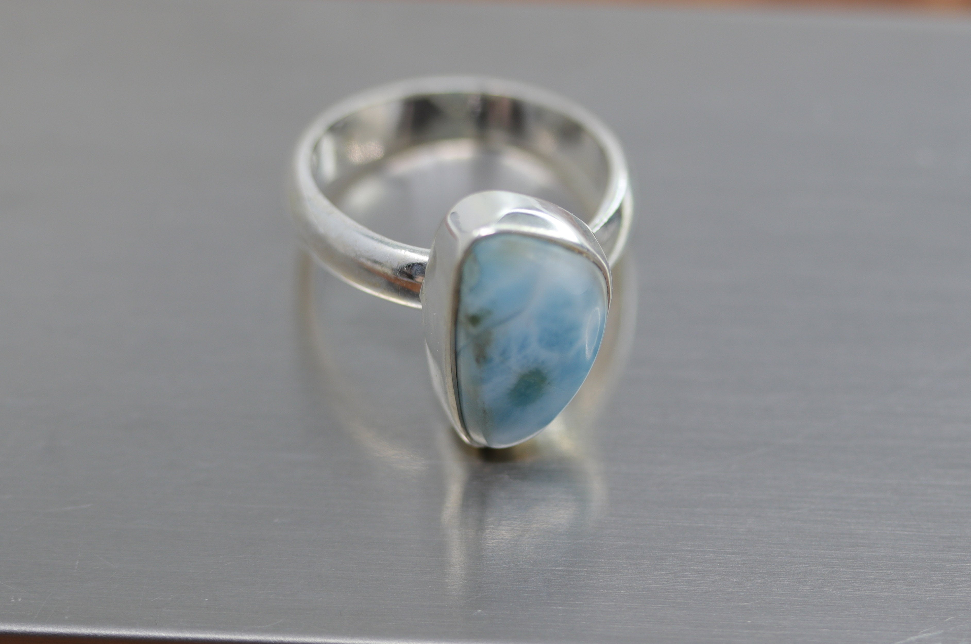 A beautiful Southwest Style gemstone ring made from sterling silver and larimar. The ring size is adjustable and fits sizes 6 to 8 and it is 3/4" in length.