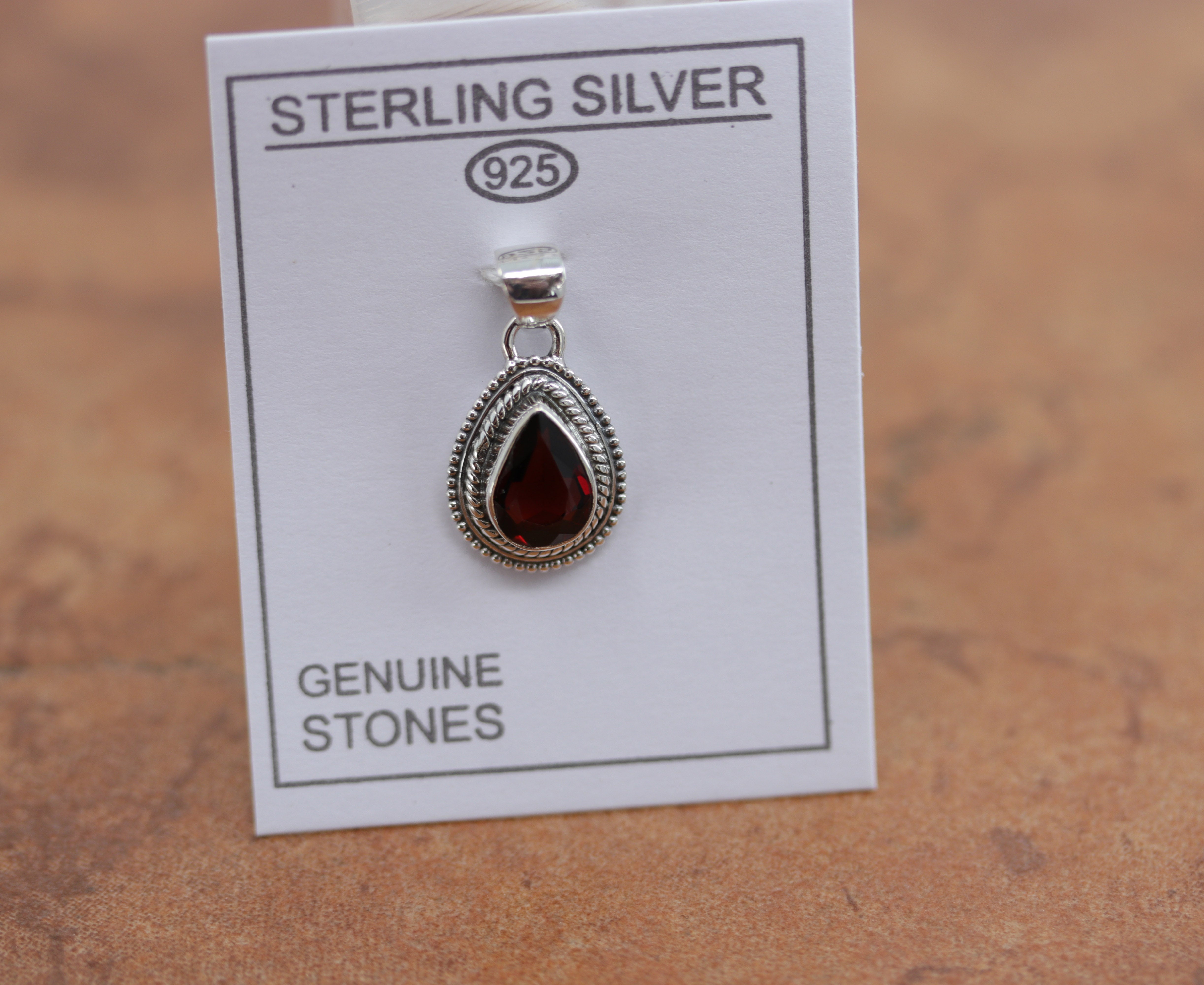 A beautiful oval pendant made from Sterling Silver and garnet. It is about 7/8" in length including the bail, and about 1/2" in width. 