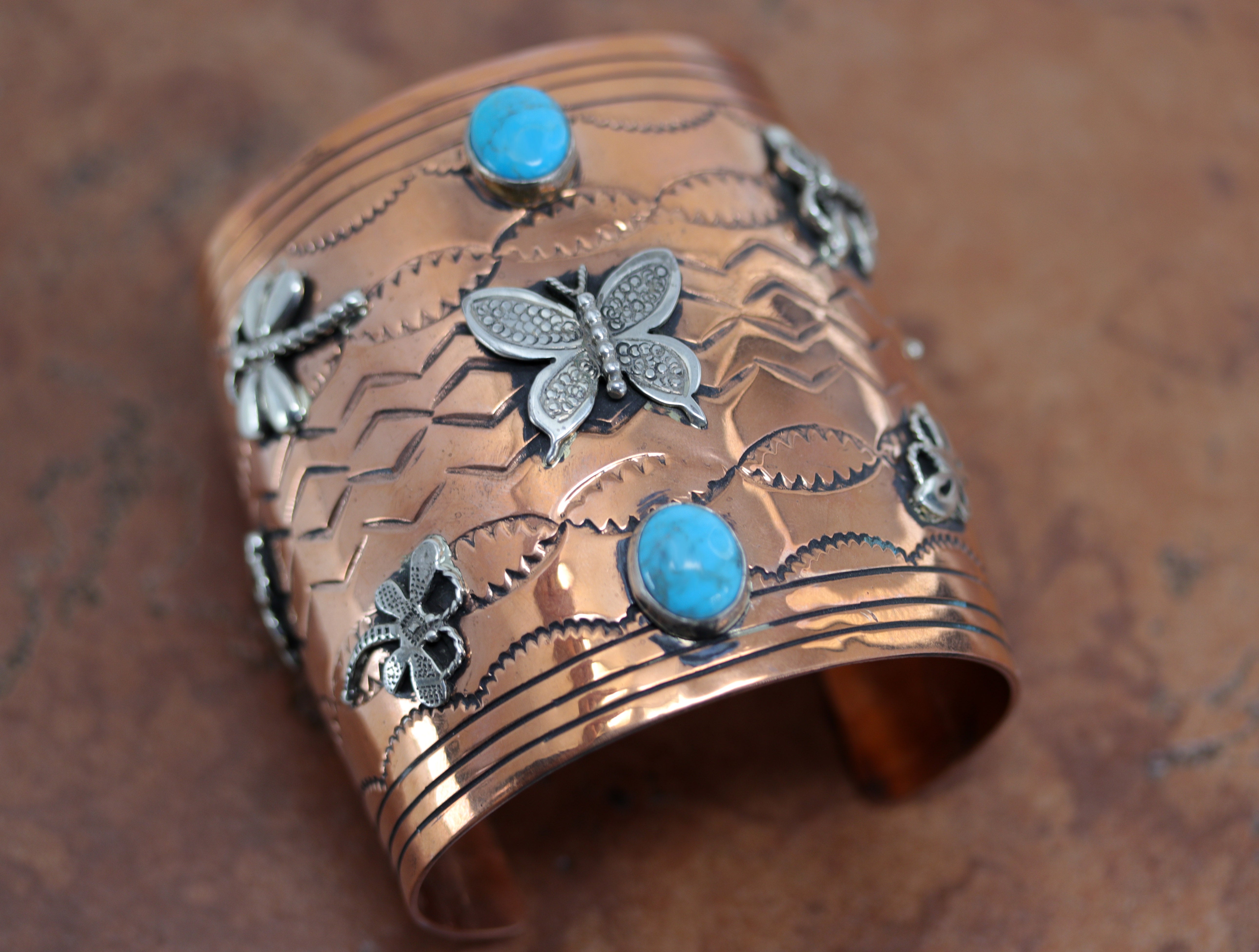 A beautiful Navajo Native American butterfly bracelet. It is made from copper, turquoise, and sterling silver. It is about 6 1/8" around and about 3" wide at the widest point. The opening is about 1 3/4".