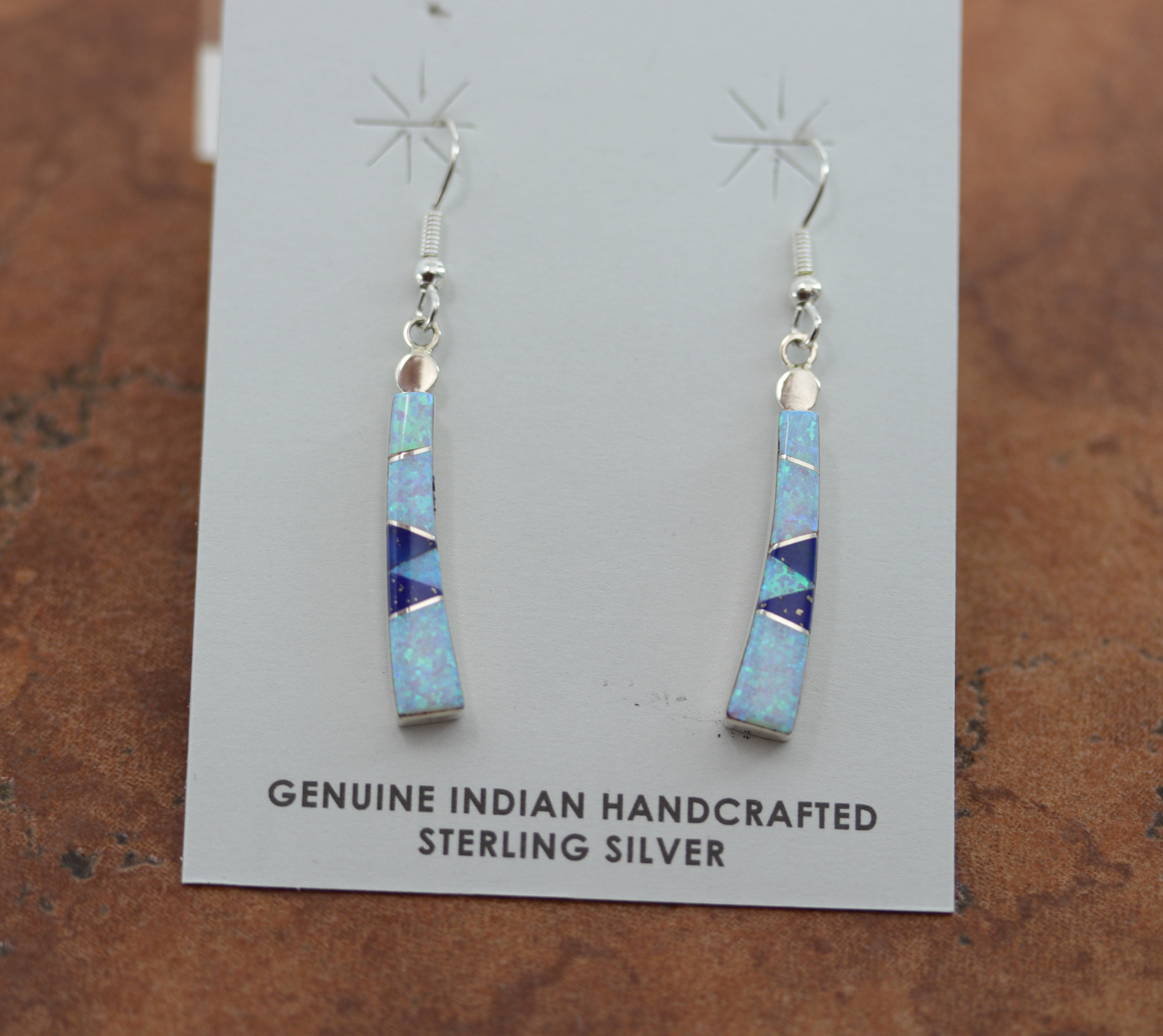 Authentic Zuni Native American earrings. They are made from sterling silver and created opal. The earrings are 2" in length including the hook and 1/4" in width.