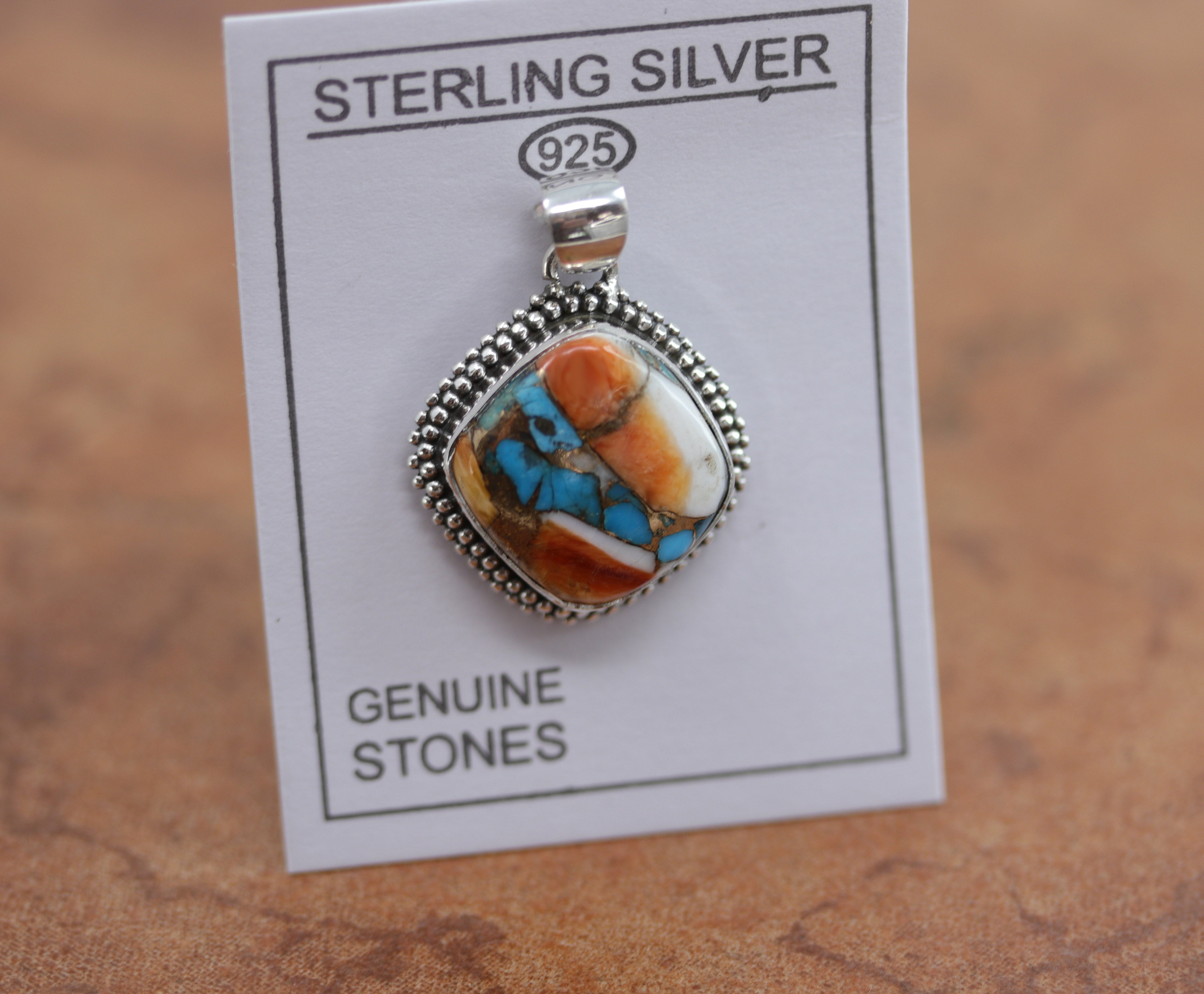 A beautiful pendant made from sterling silver and mojave turquoise. The pendant is about 1 1/4" in length including the hook, and 1" in width.