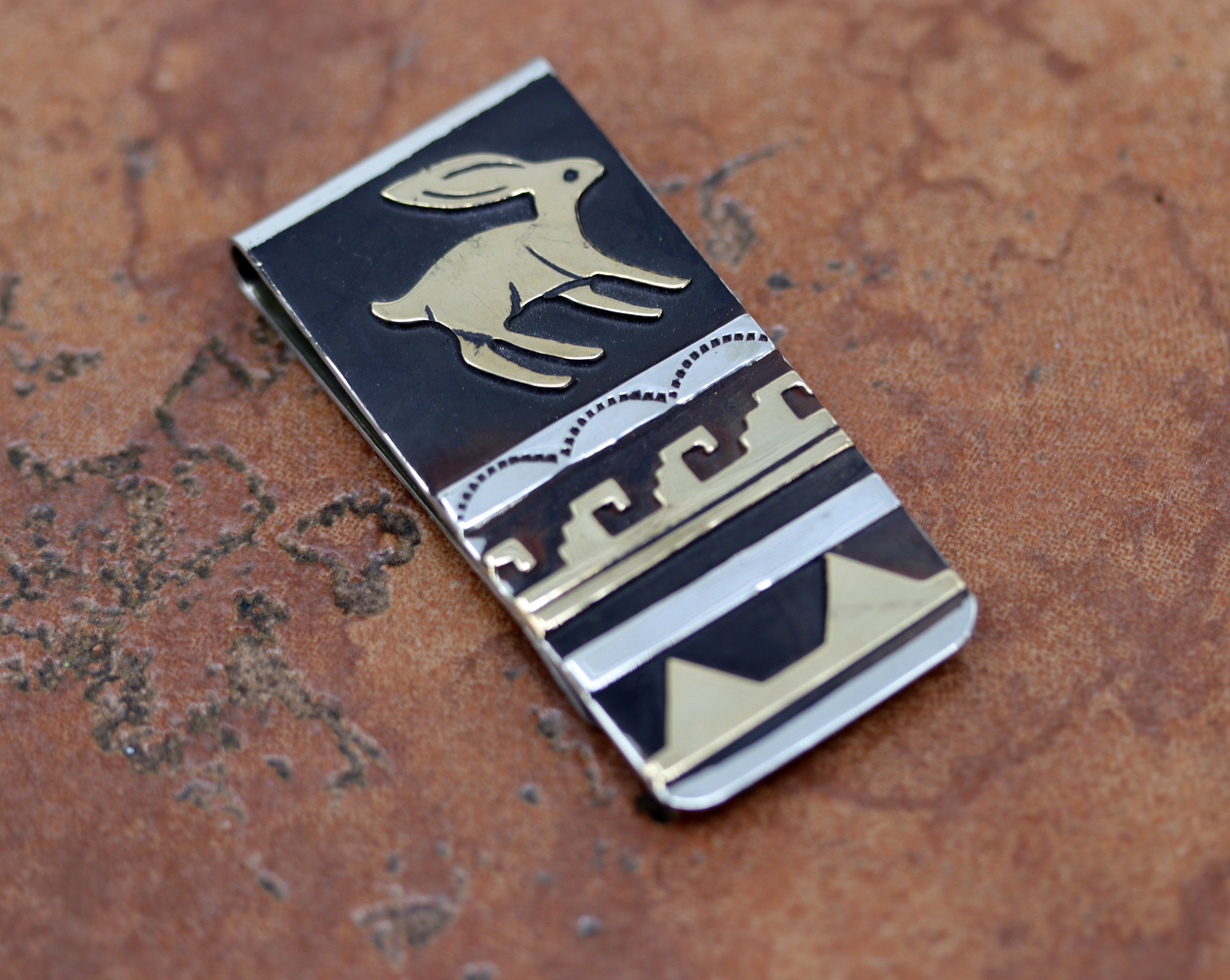 Navajo Native American money clip. It is made from sterling silver, and gold overlay. The lower part of the money clip is made from nickel to give it more durability. It is about 2 1/8" in length and 1" wide.