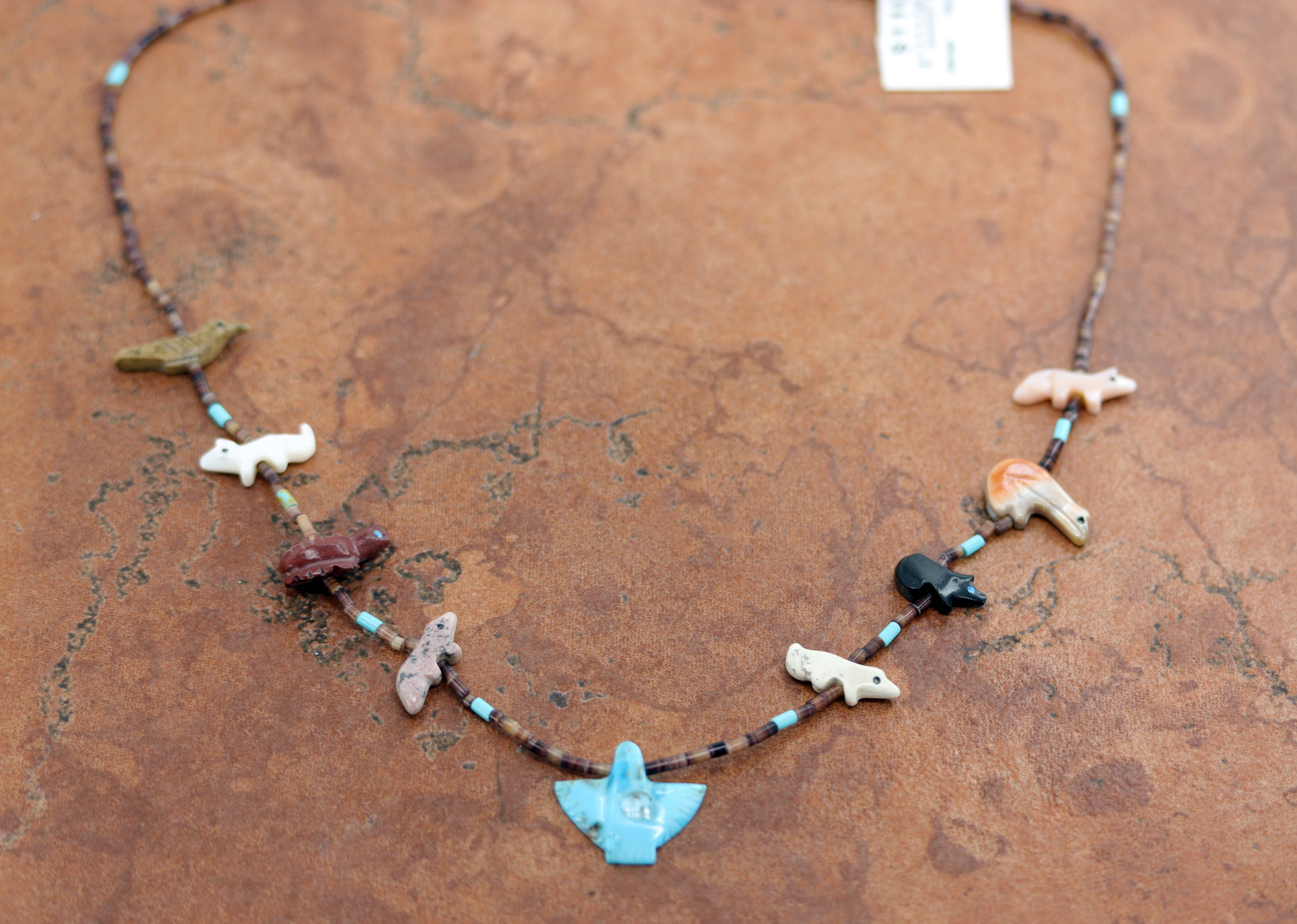 A beautiful Navajo multi-color animal fetish necklace by Hector Goodluck. The necklace is 19" in length, and the eagle measures about 3/4" in width.