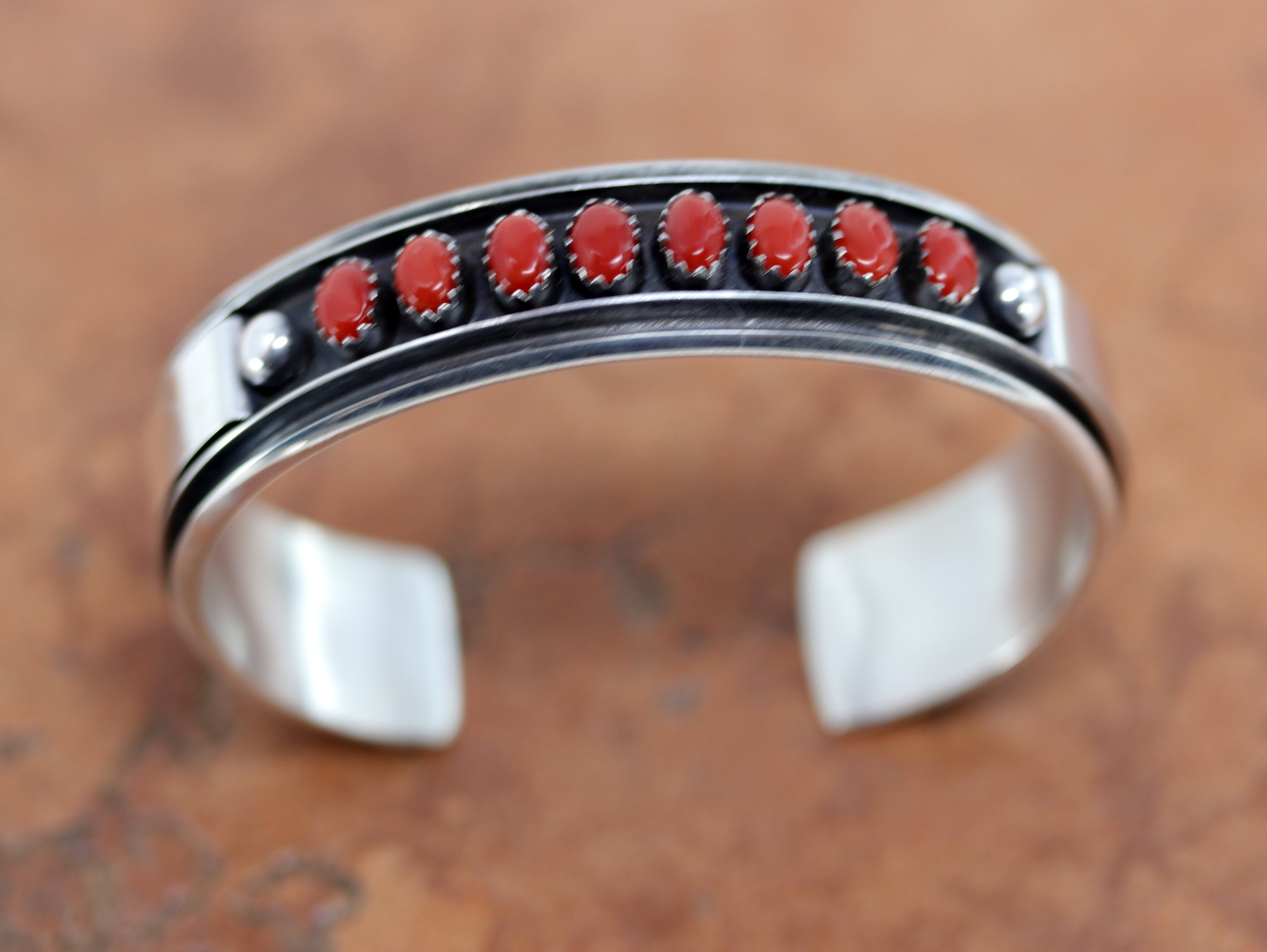 Beautiful Navajo Native American bracelet. It is made from sterling silver and coral. It is about 5 5/8" around and about 3/4" wide at the widest point. The opening is about 1", and partly flexible.