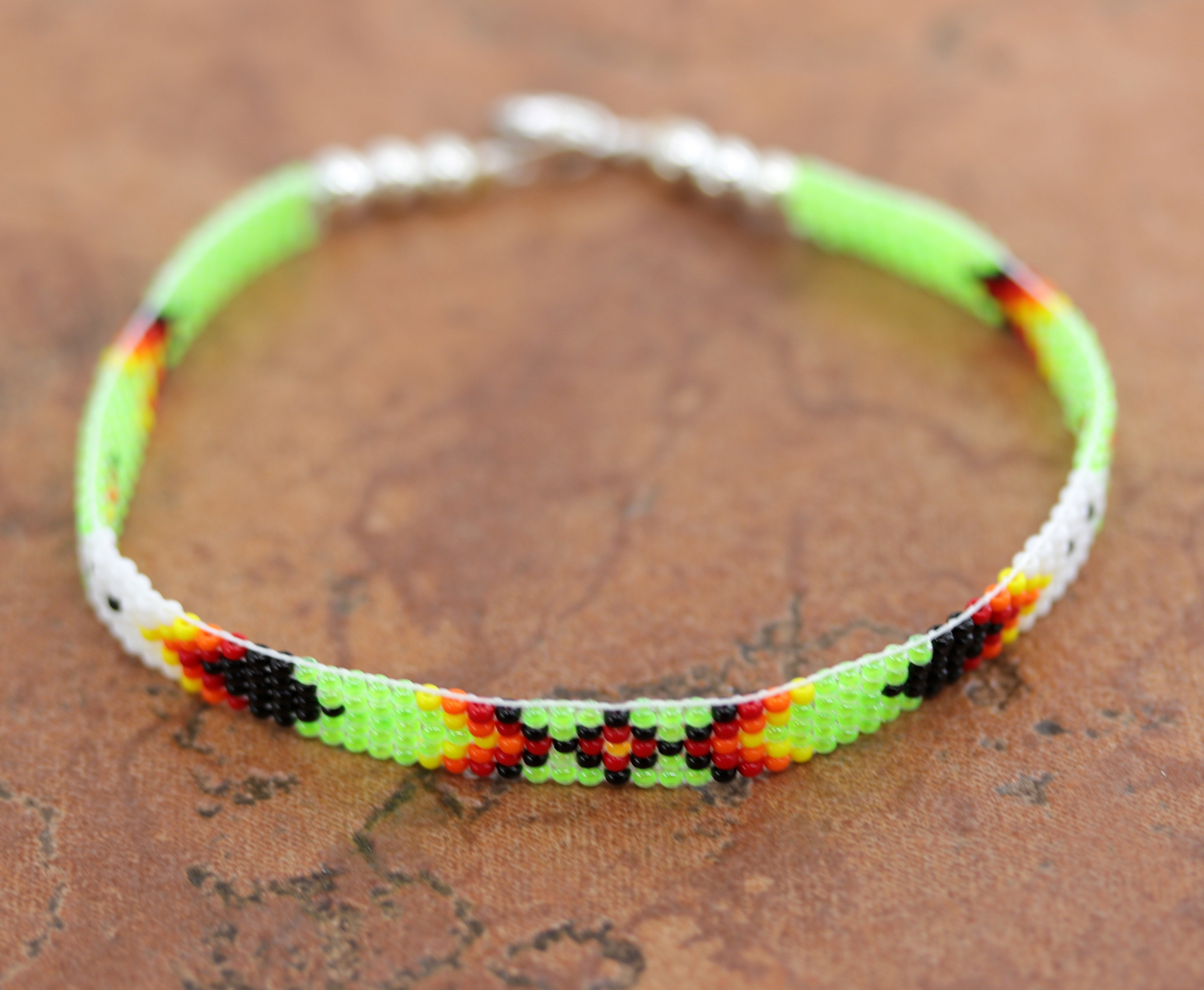 A beautiful Navajo green and white beaded bracelet. It is about 7 7/8" from end to end and the width is 1/4" at the widest point.