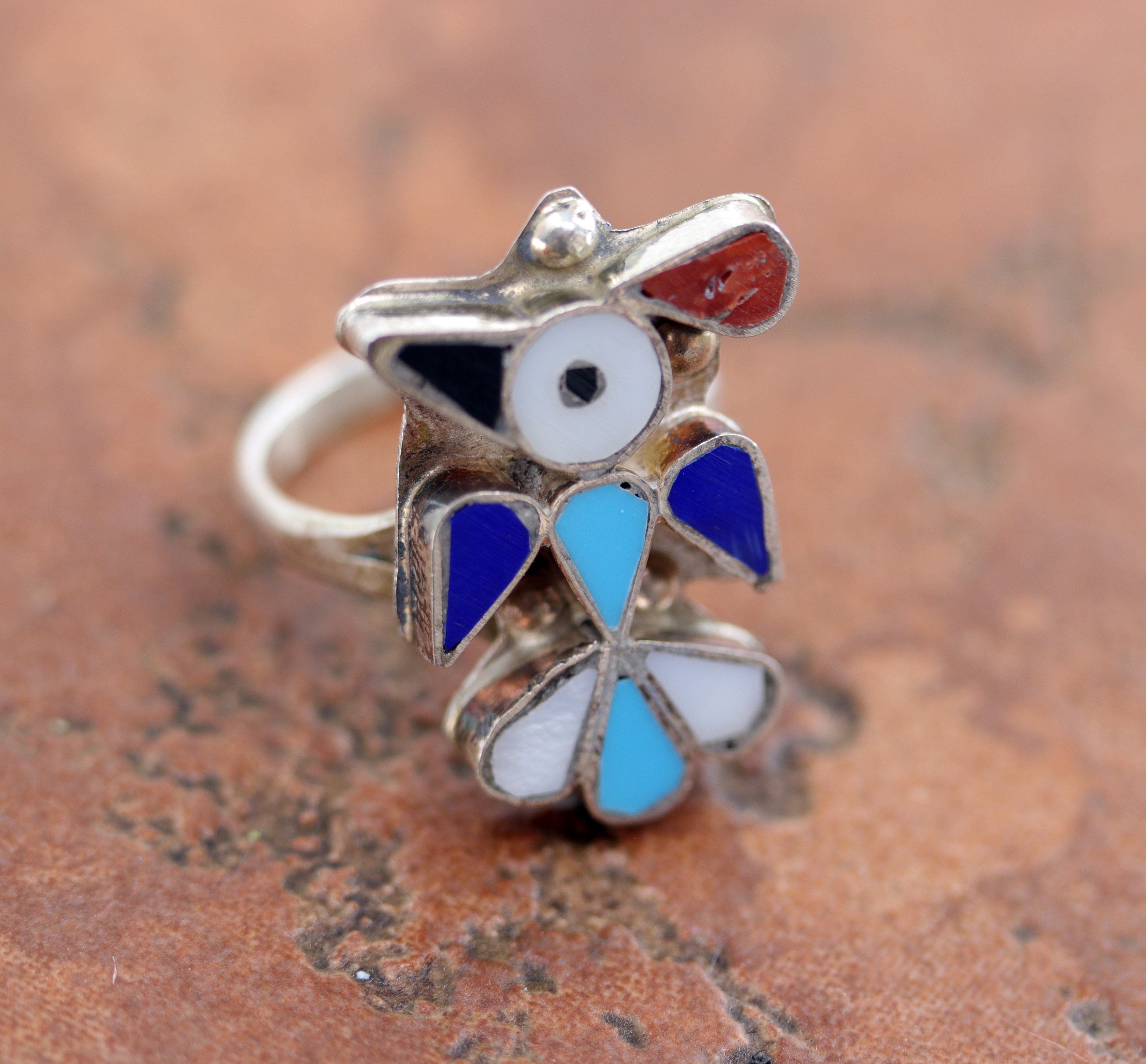 Lovely Zuni Native American Thunderbird ring. It is made from sterling silver and multi-stone inlay. The ring size 6 and it is 1" in length.