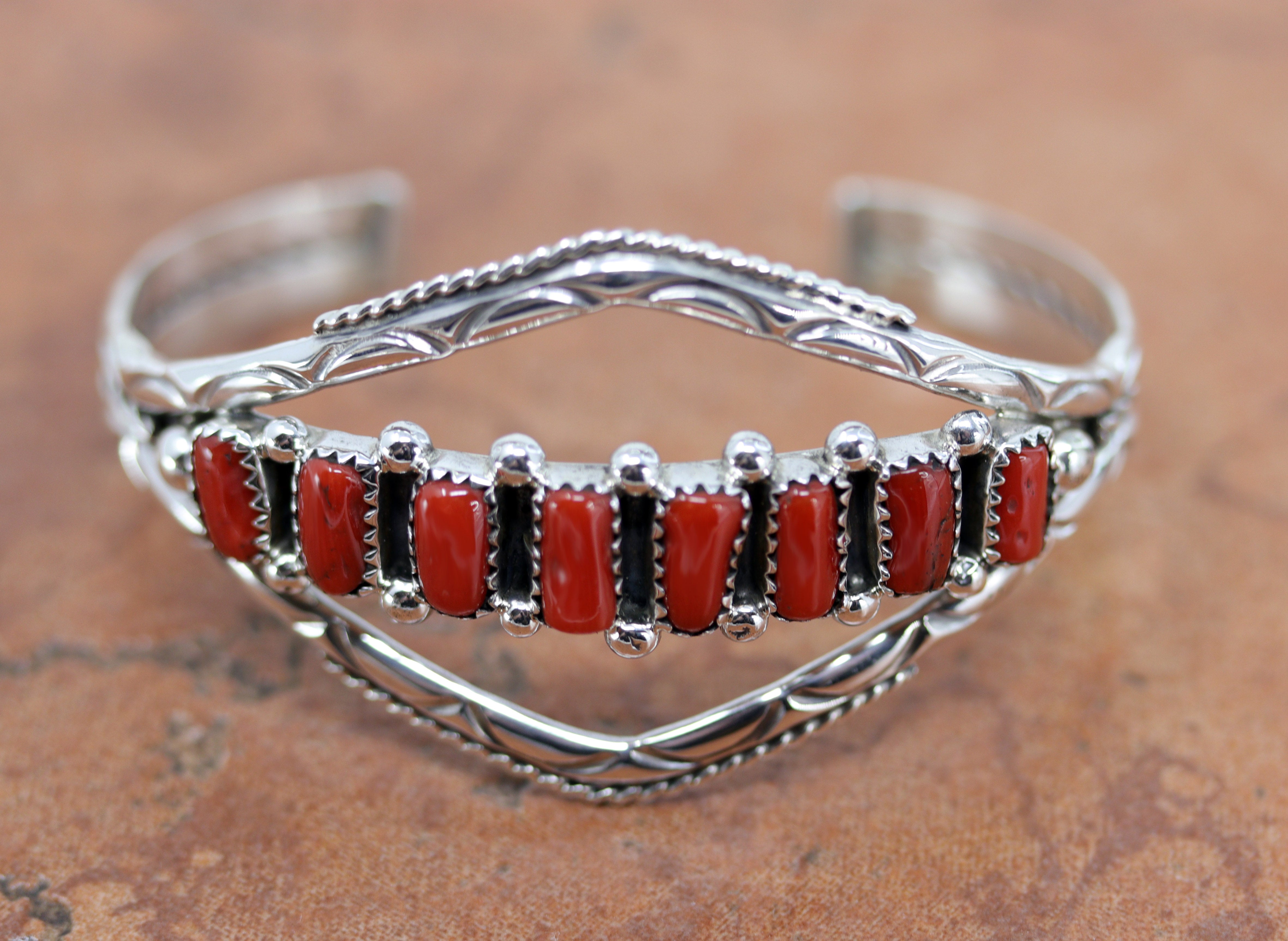 Beautiful Navajo Native American bracelet. It is made from sterling silver and coral. It is about 5 1/2" around and about 1 1/2" wide at the widest point. The opening is about 1", and partly flexible.&nbsp;