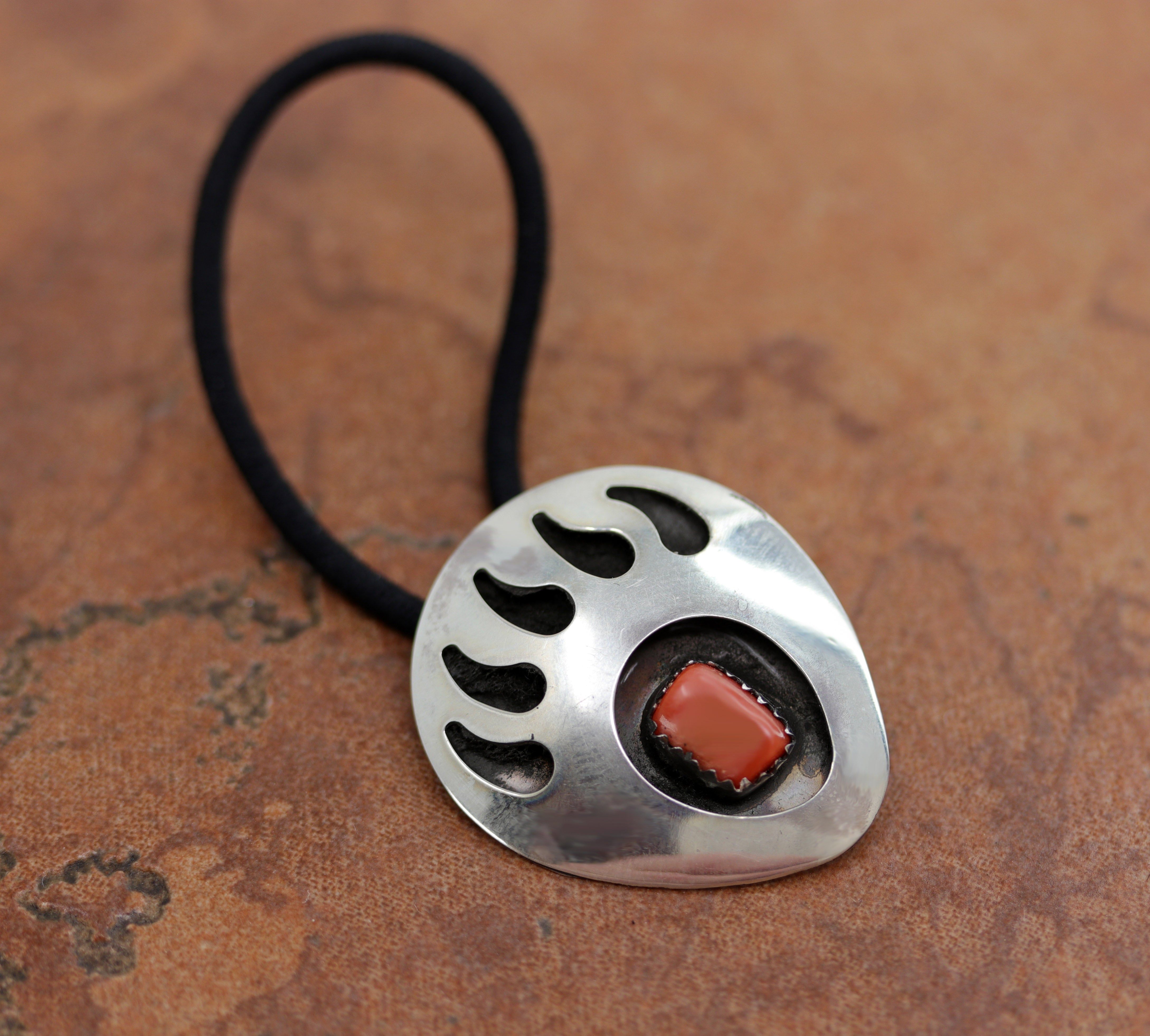 Beautiful Navajo Native American bear paw shaped hair tie made from a hair band, sterling silver, and coral. It is 2 3/4" long (including the hair tie) and 1 1/8" wide.