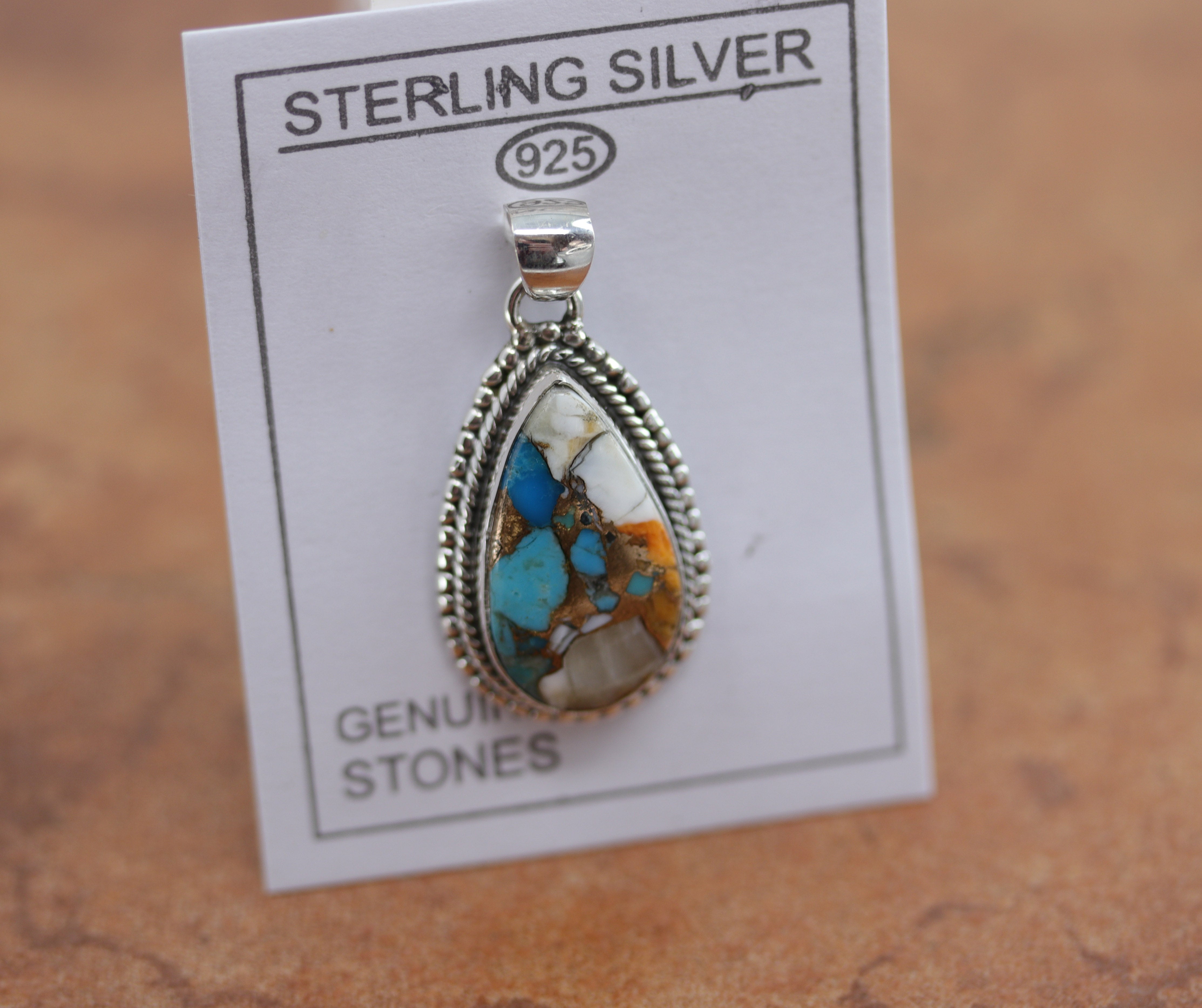 A beautiful pendant made from sterling silver and mojave turquoise. The pendant is about 1 1/2" in length including the hook, and 7/8" in width. 