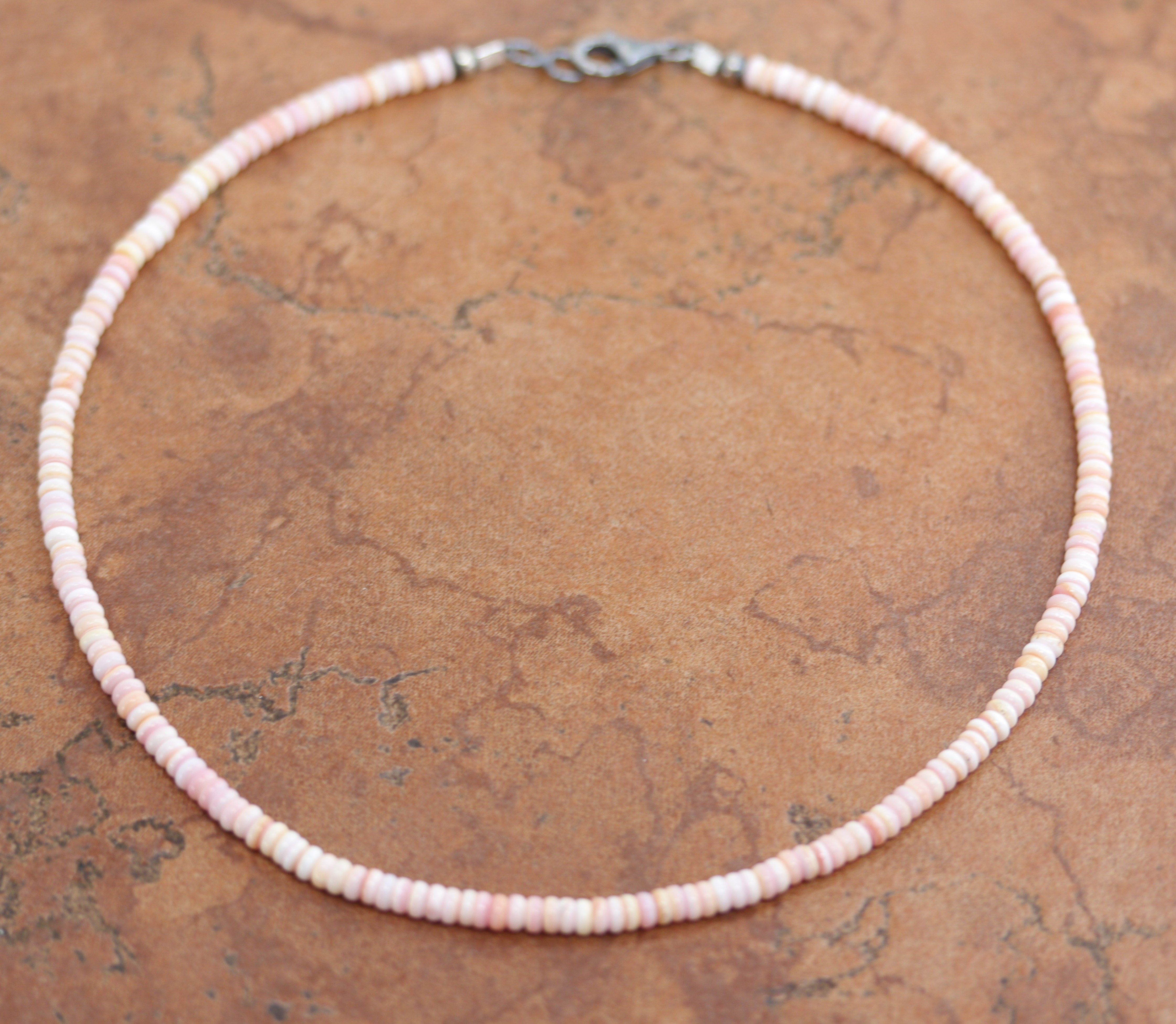 A beautiful silver Navajo Pearl Pink Heishi choker necklace. The necklace is 16 1/2" in length and the beads measure 4 mm.