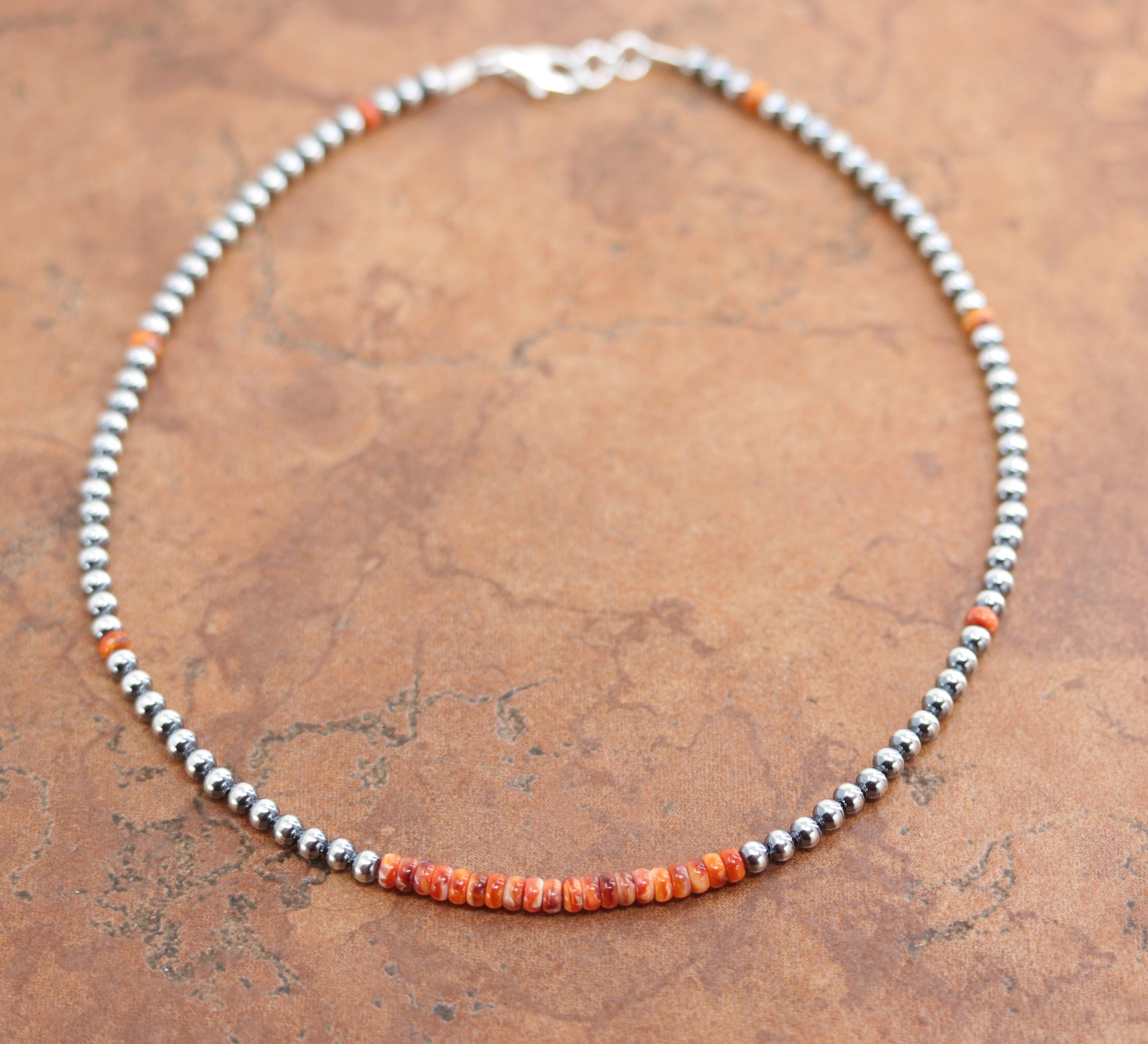 A beautiful silver Navajo Pearl choker necklace with spiny oyster heishi. The necklace is 16" in length and the beads measure 4 mm.