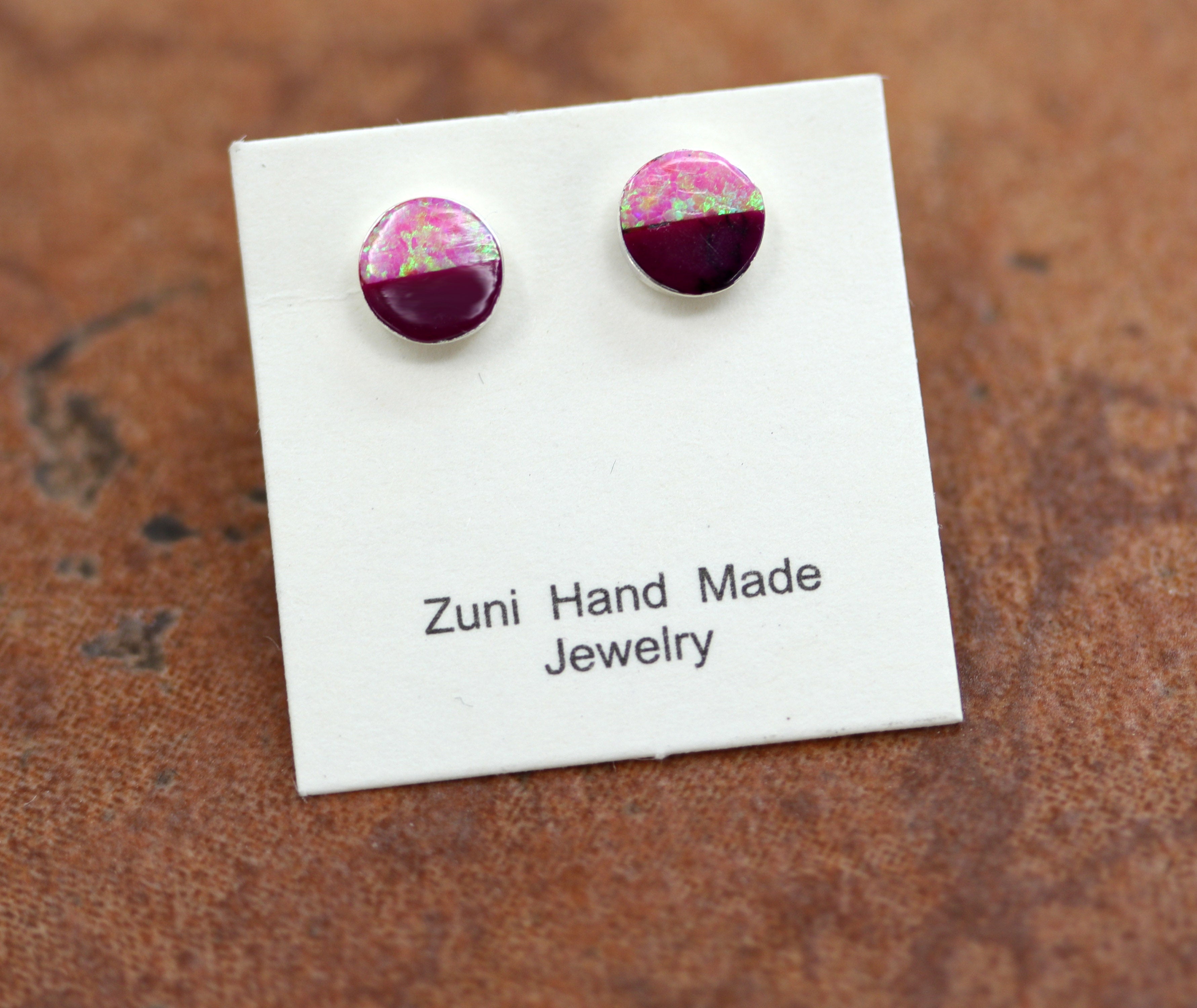 They are made from sterling silver, sugilite, and created opal. The earrings are about 3/16" in diameter.