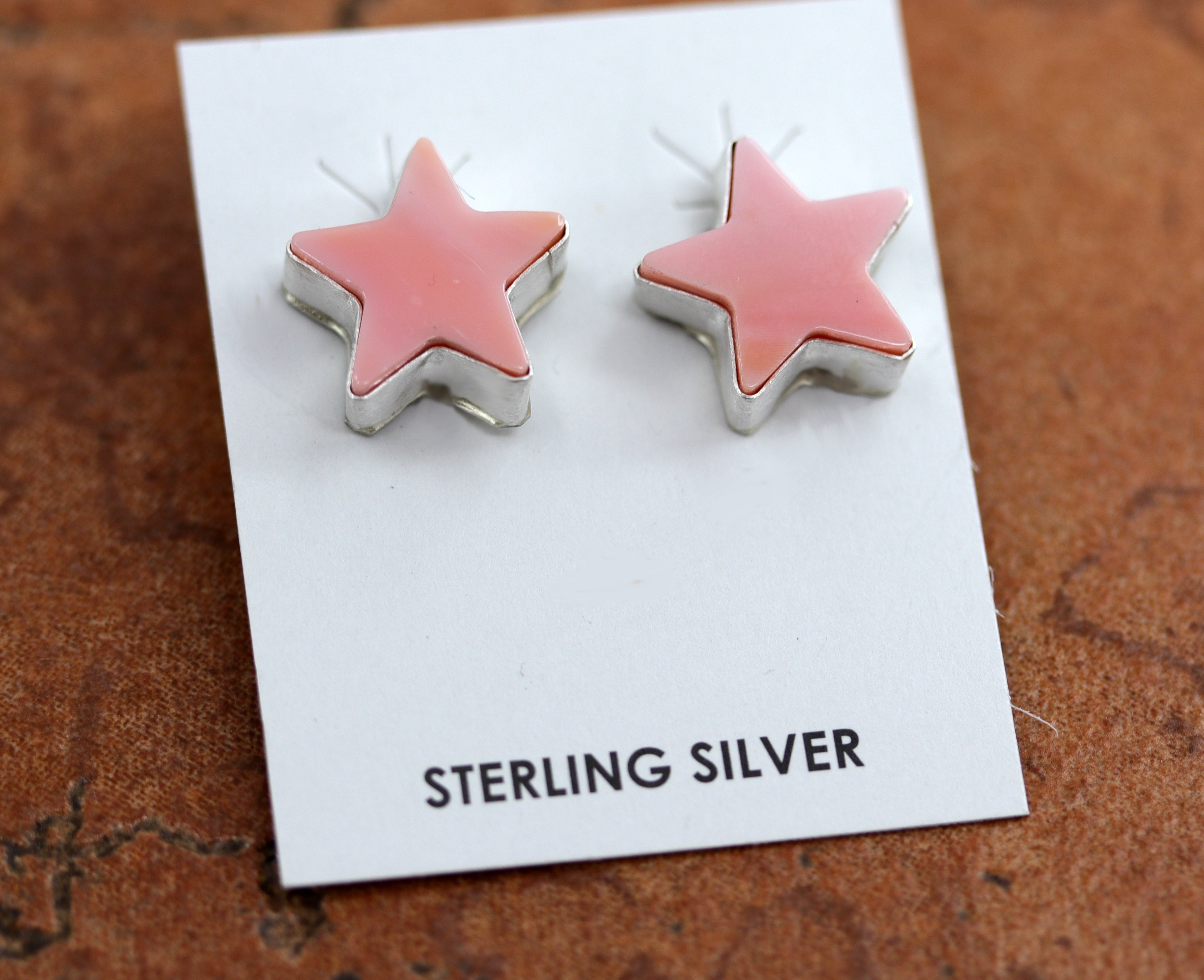 Beautiful Navajo stud star earrings by J Dixon. They are made from sterling silver and pink quartz. The earrings are 3/4" in length.