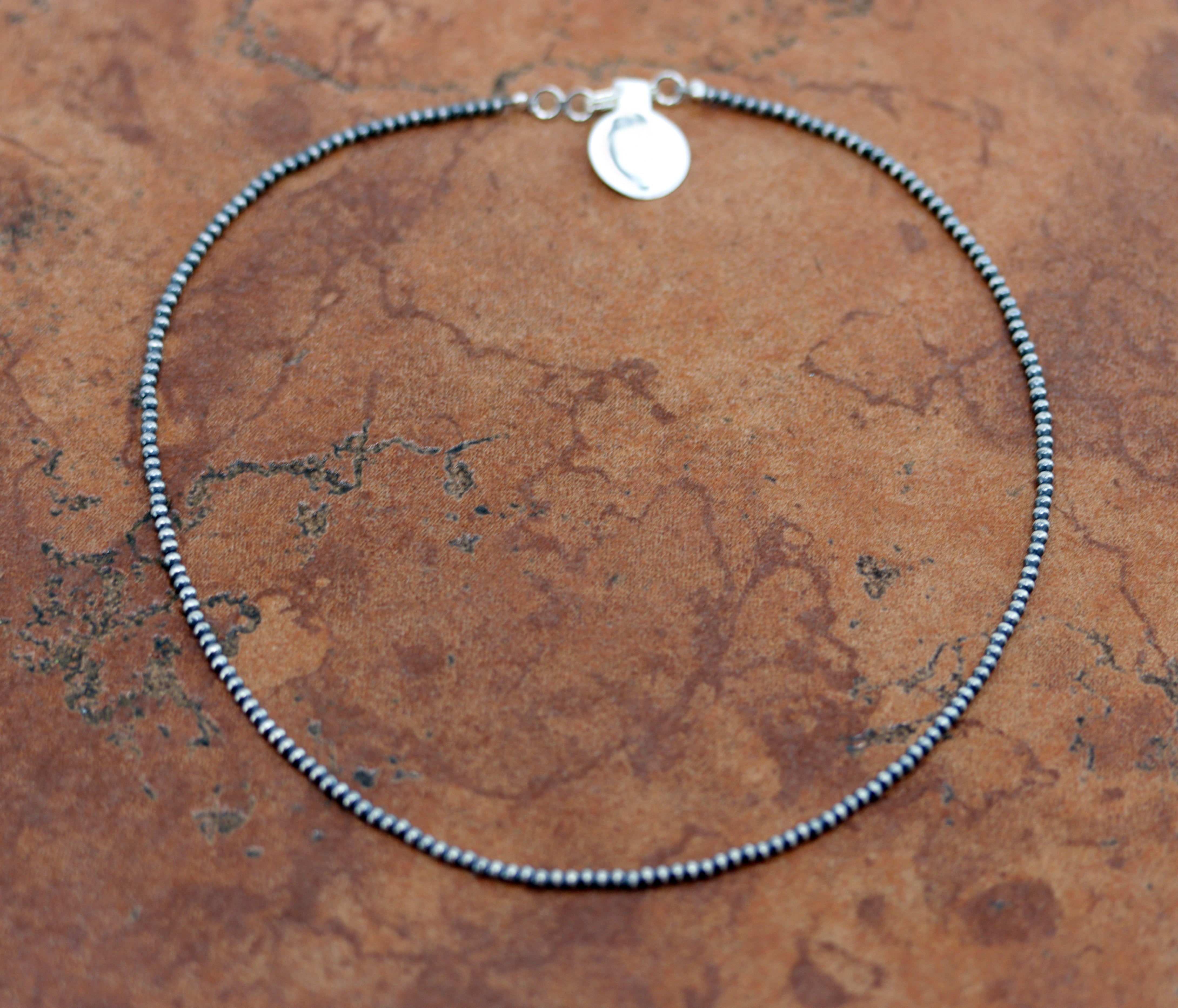 A beautiful silver Navajo Pearl Native American choker necklace. The necklace is 14" in length and the beads measure 3 mm.