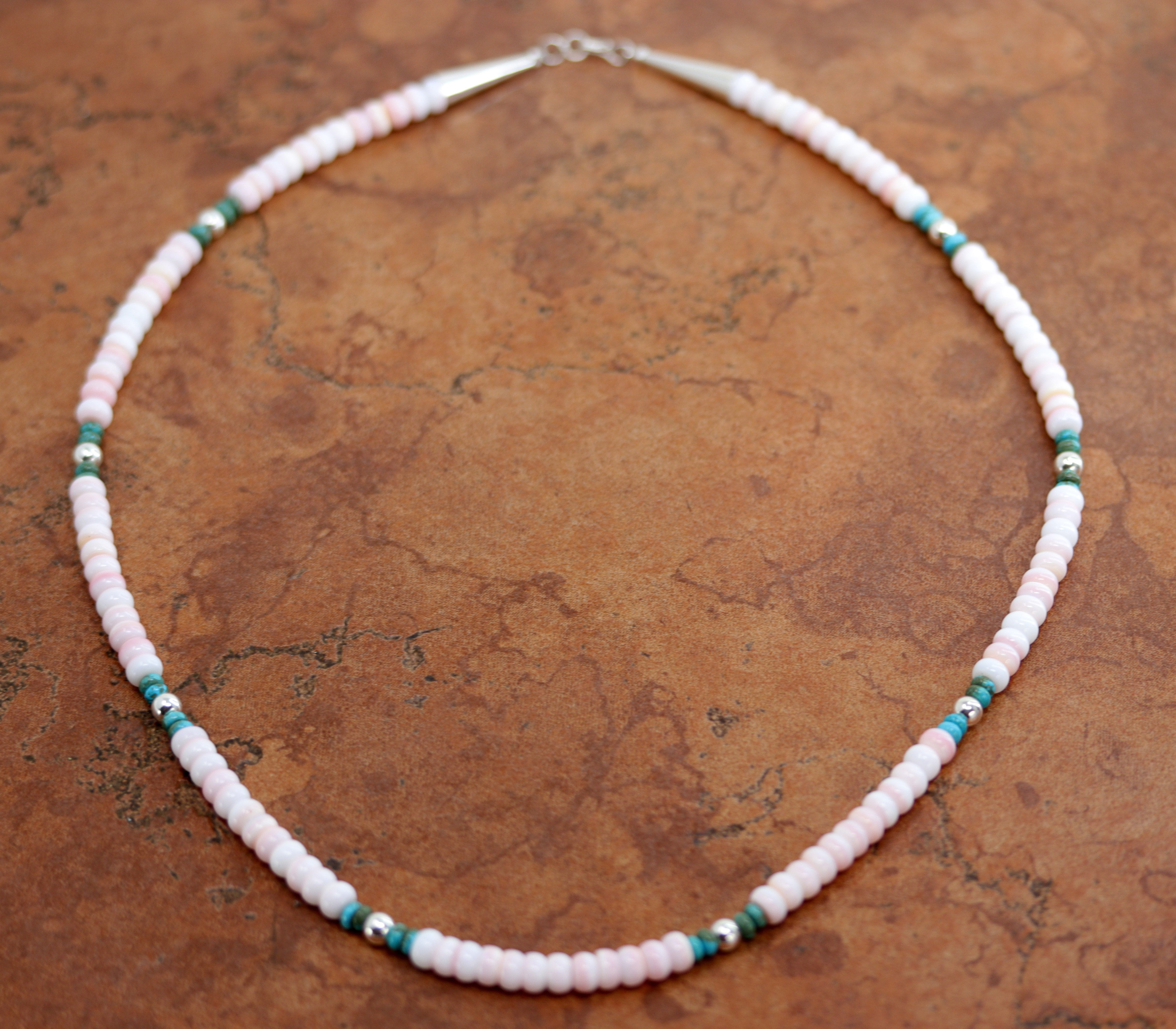 A beautiful silver Navajo Pearl Pink Heishi Native American necklace. The necklace is 22" in length and the beads measure 1/4" wide.