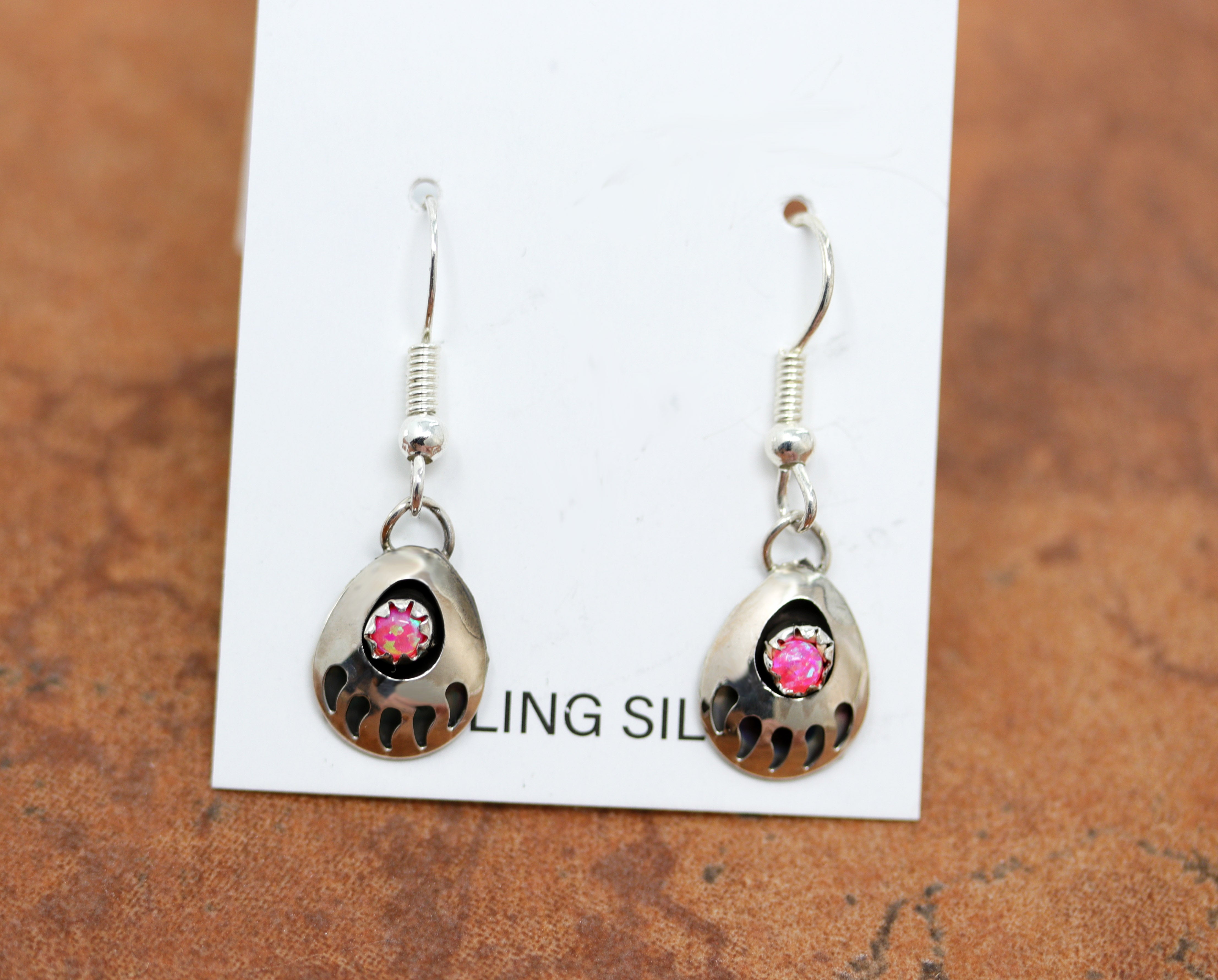 Beautiful Navajo Native American earrings made from sterling silver and pink created opal. The earrings are about 1 1/4" in length including the hook and 1/2" wide.