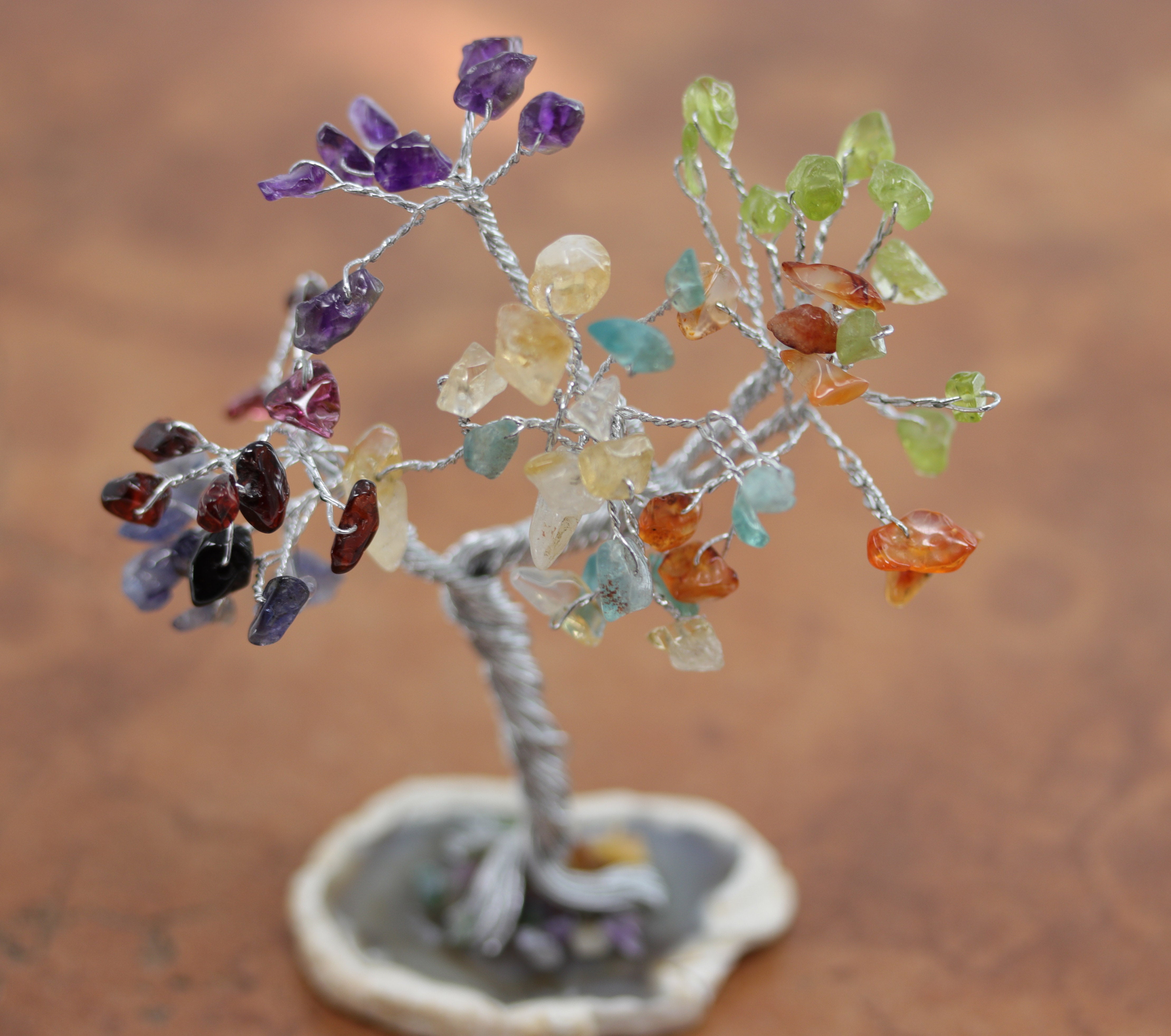 A beautiful 7 chakra tree of life crystal tree. It is made from different crystal petals. The pendant is about 4 1/2" in length by 3 3/4" wide.