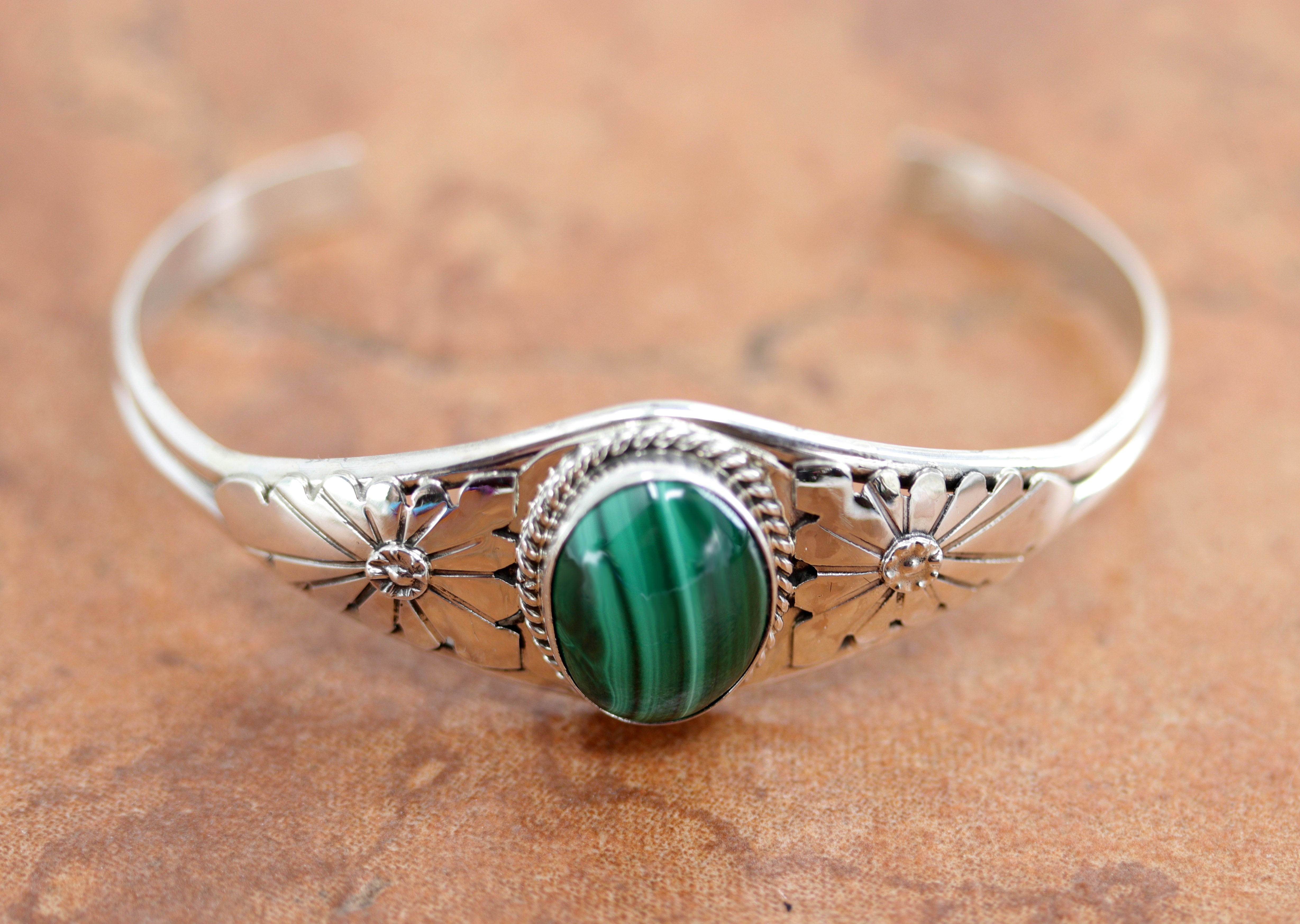 A beautiful Navajo Native American bracelet by R Yazzie. It is made from sterling silver and malachite. It is about 5 1/4" around and about 7/8" wide at the widest point. The opening is about 1 1/4", and partly flexible.