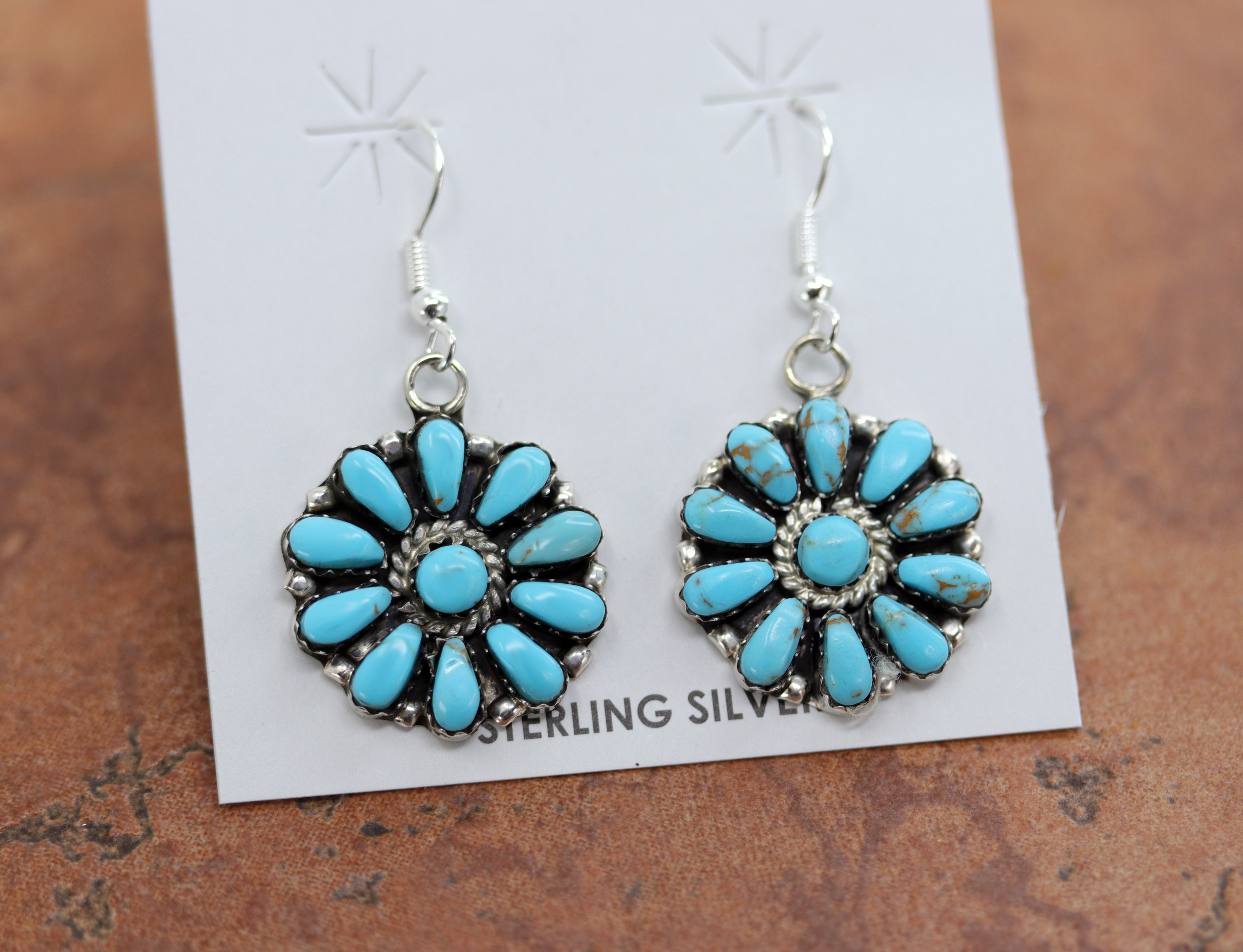 Authentic Native American cluster earrings by L Williams. They are made from sterling silver and man made turquoise. The earrings are about 1 7/8" in length including the hook and 7/8" in width.