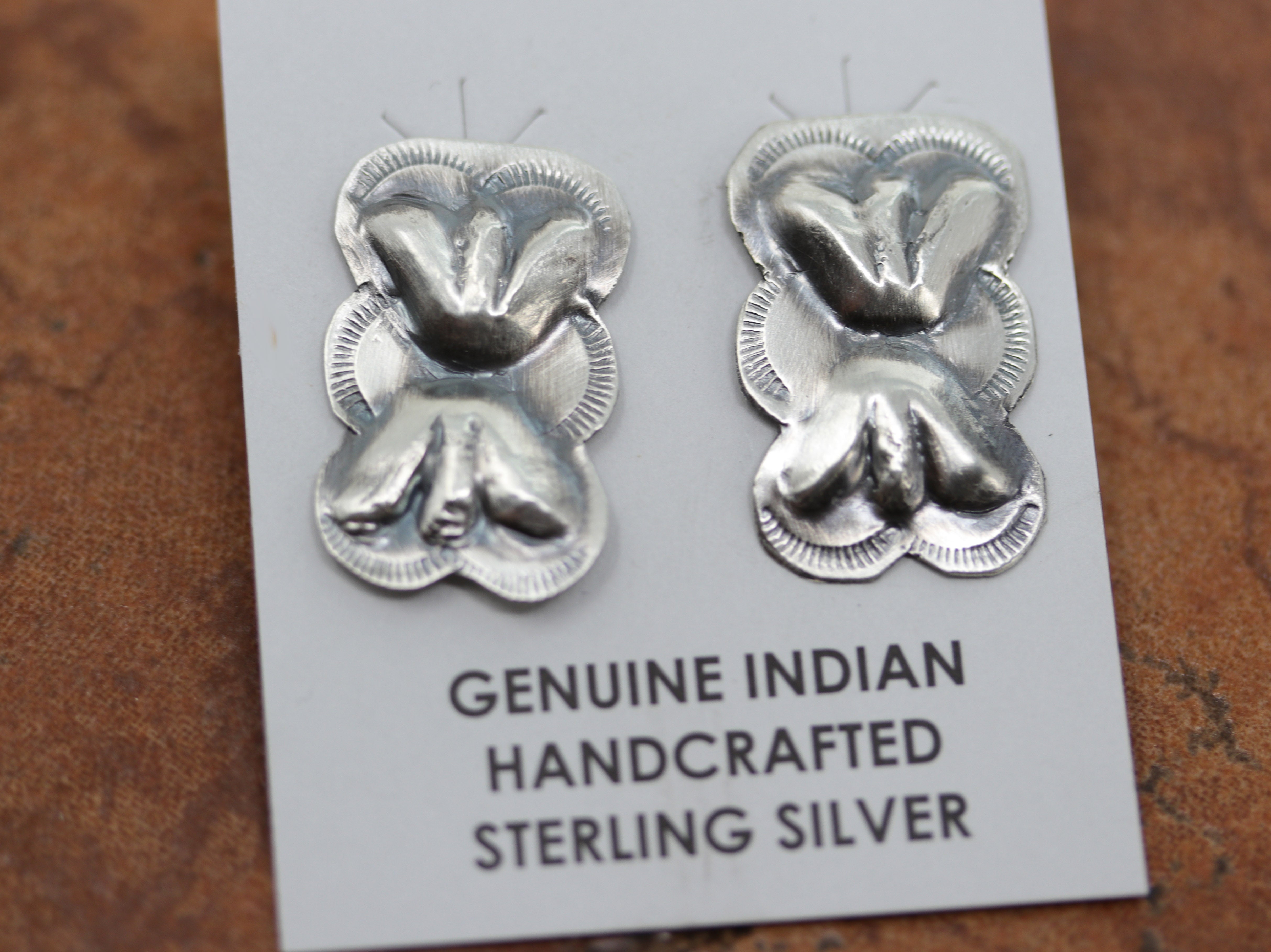 Navajo Native American earrings by Gabrielle Yazzie. They are made from sterling silver and turquoise. The earrings are 2 1/2" in length including the hook and 1 3/8" in width.