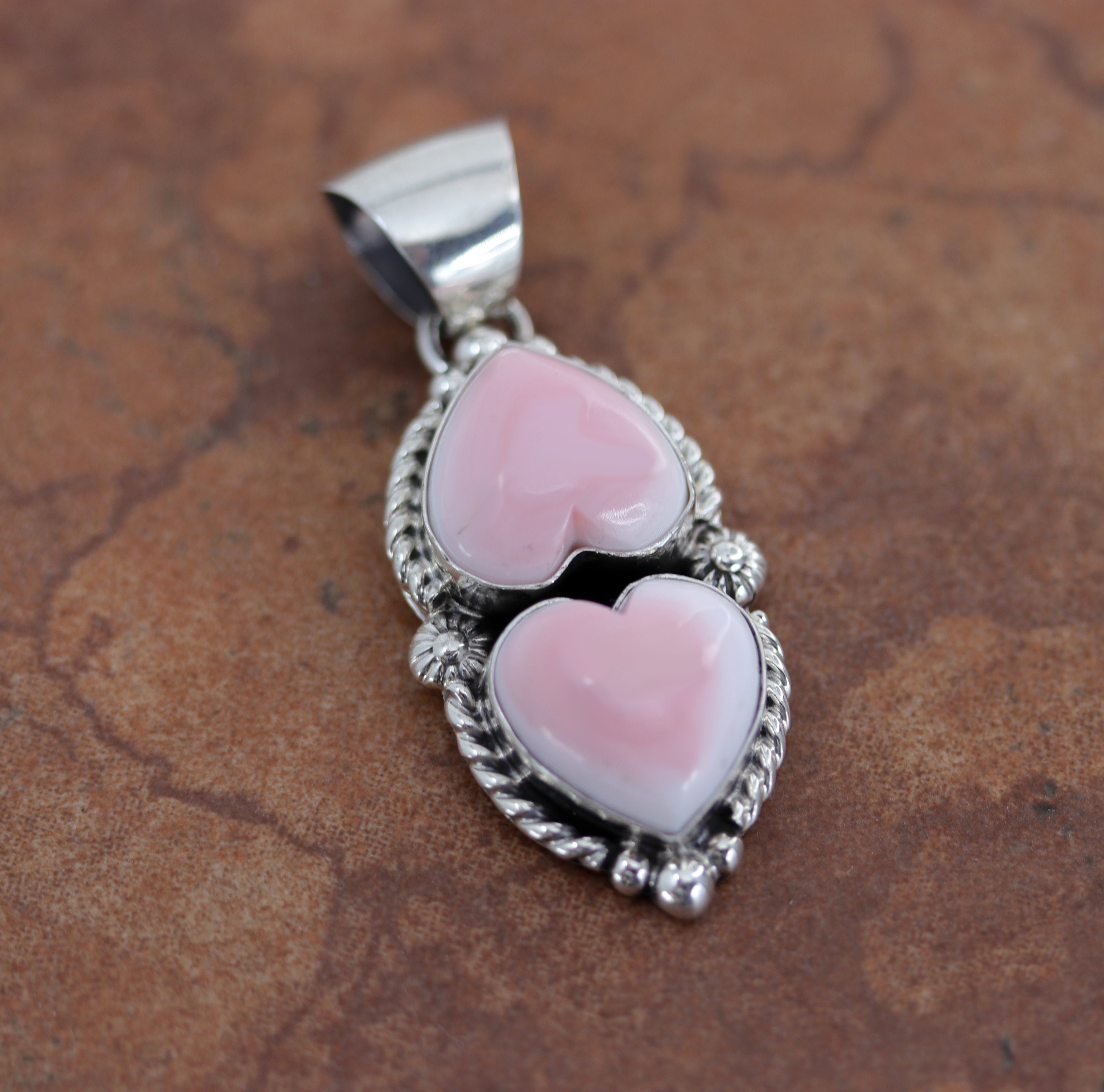 Silver pendant with two heart gemstones made from pink quartz