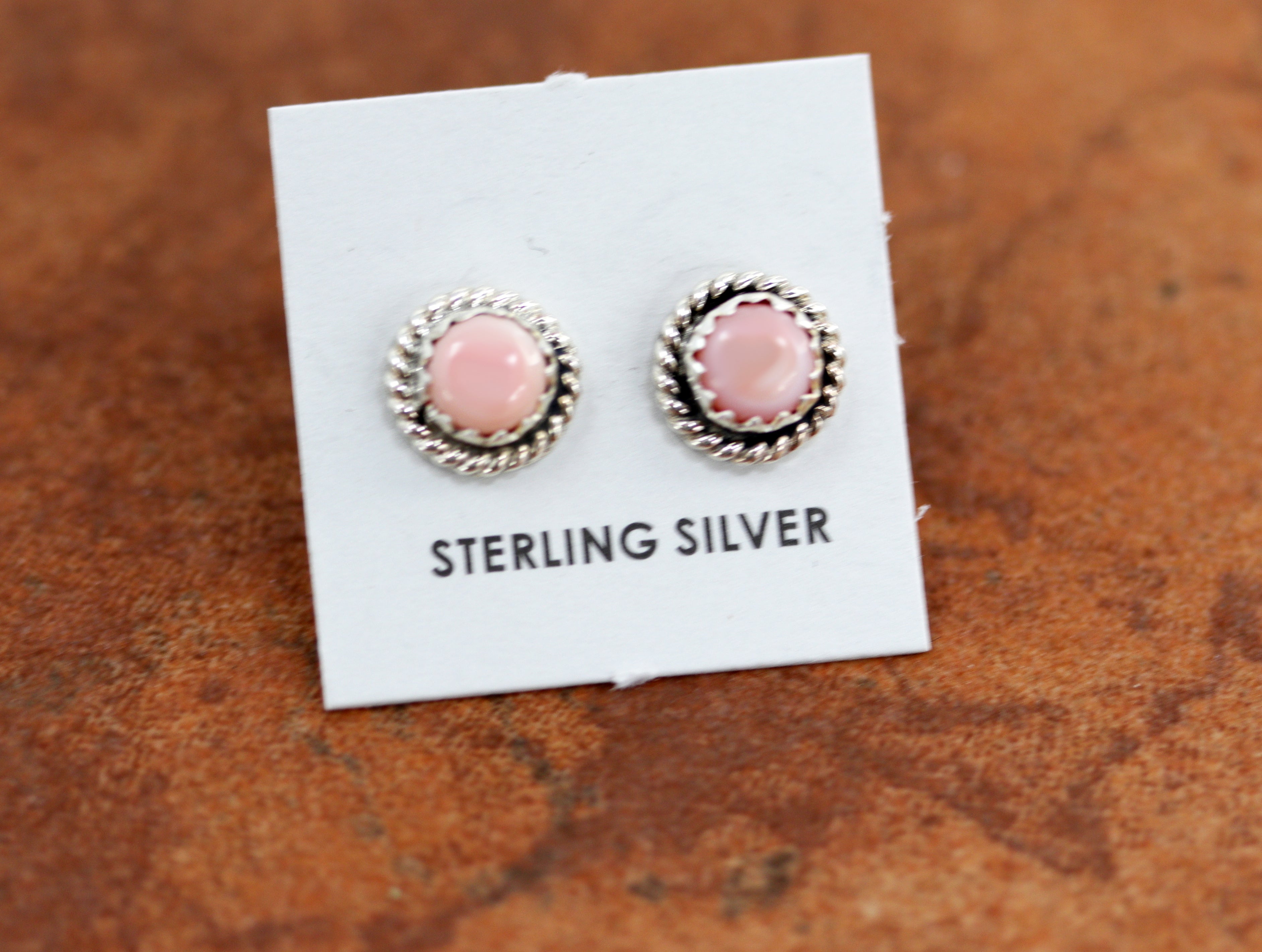 Circular stilver stud earrings with round pink stones