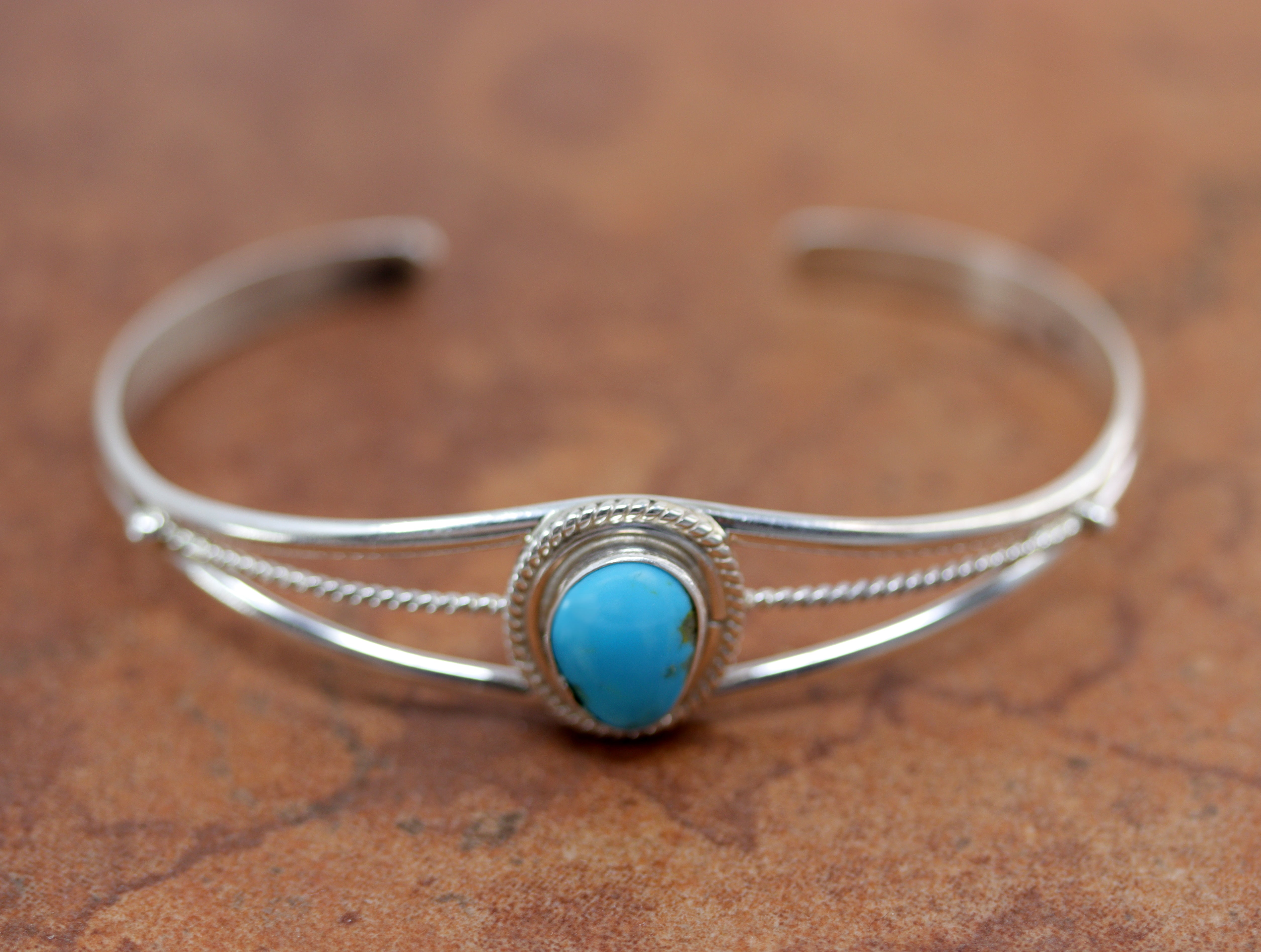 Silver bracelet with round turquoise gemstone in center