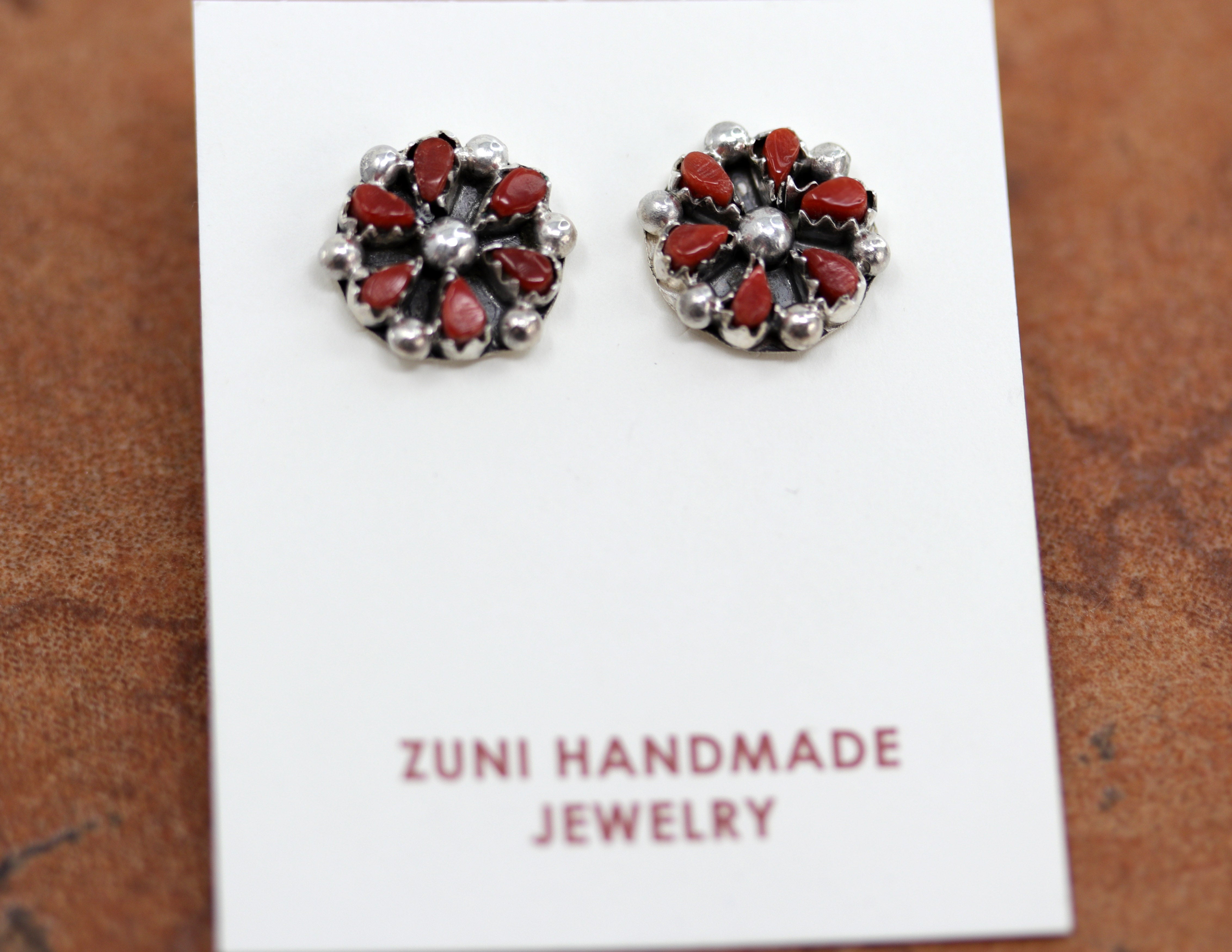 Zuni Native American stud earrings with a cluster design. They are made from sterling silver and coral. Each earring is 1/2" in length.